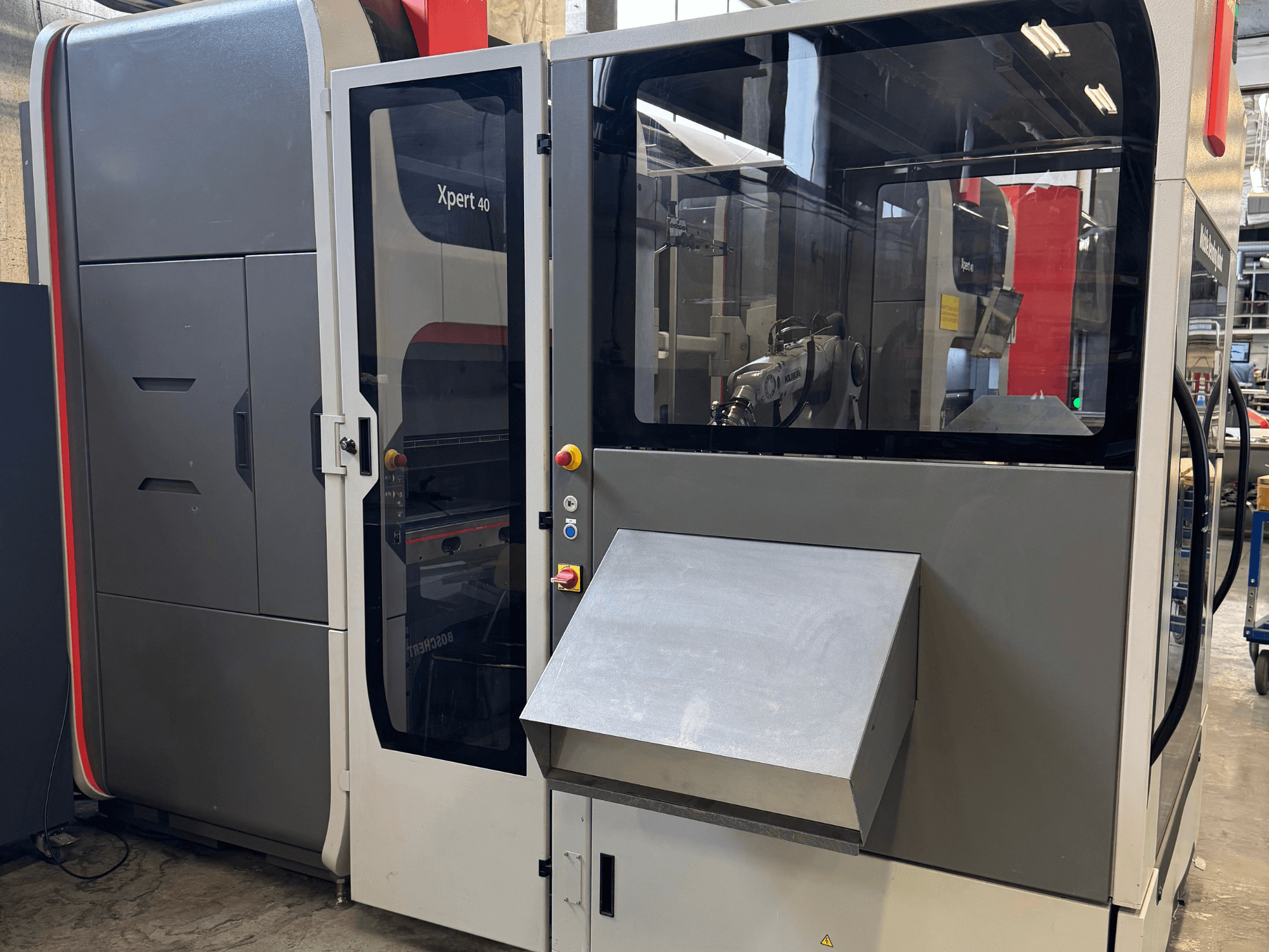Листогибочный пресс Bystronic Xpert 40/1030 на переднем плане, панель управления, стеклянный корпус и чистый дизайн.