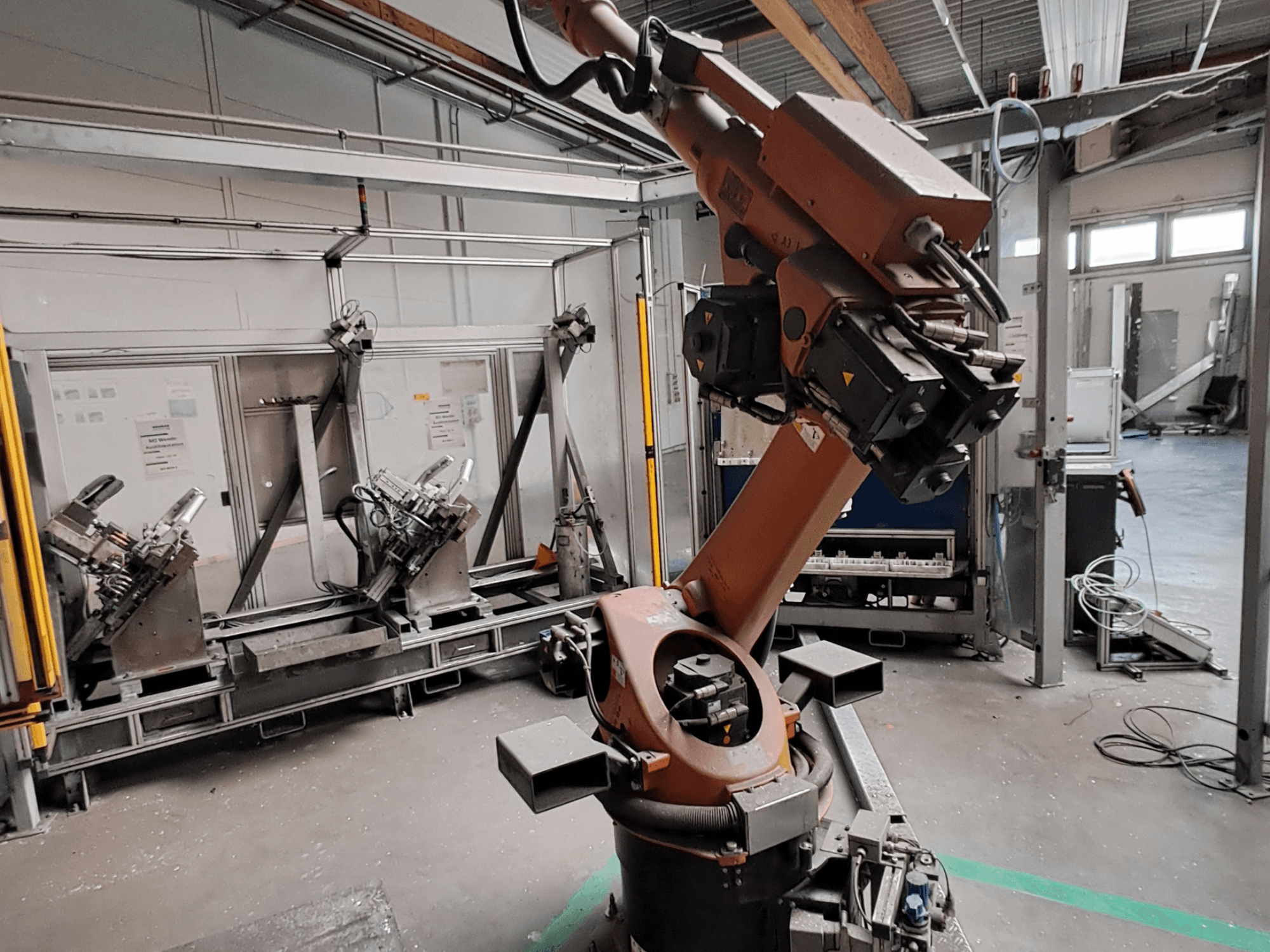 Манипулятор робота KUKA KR 30L16-2 в промышленной обстановке, вид сбоку, на котором видны шарниры манипулятора и захватные устройства.