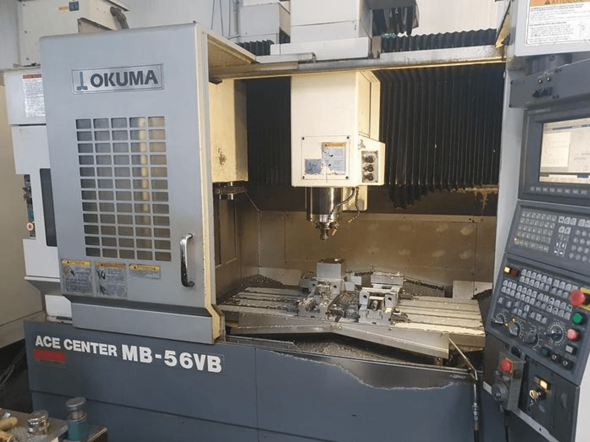 Фрезерный станок с ЧПУ Okuma ACE CENTER MB-56VB вид спереди, демонстрирующий панель управления и зону обработки.