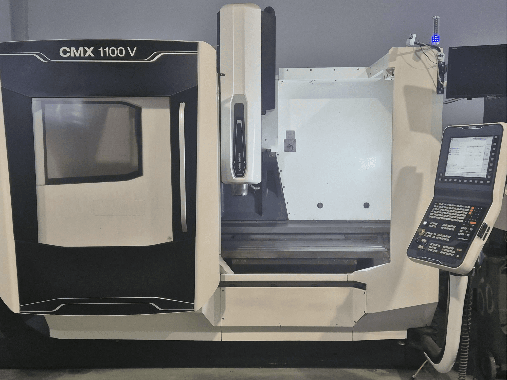Вертикальный обрабатывающий центр DMG MORI CMX 1100 V, вид спереди с панелью управления и станиной станка.