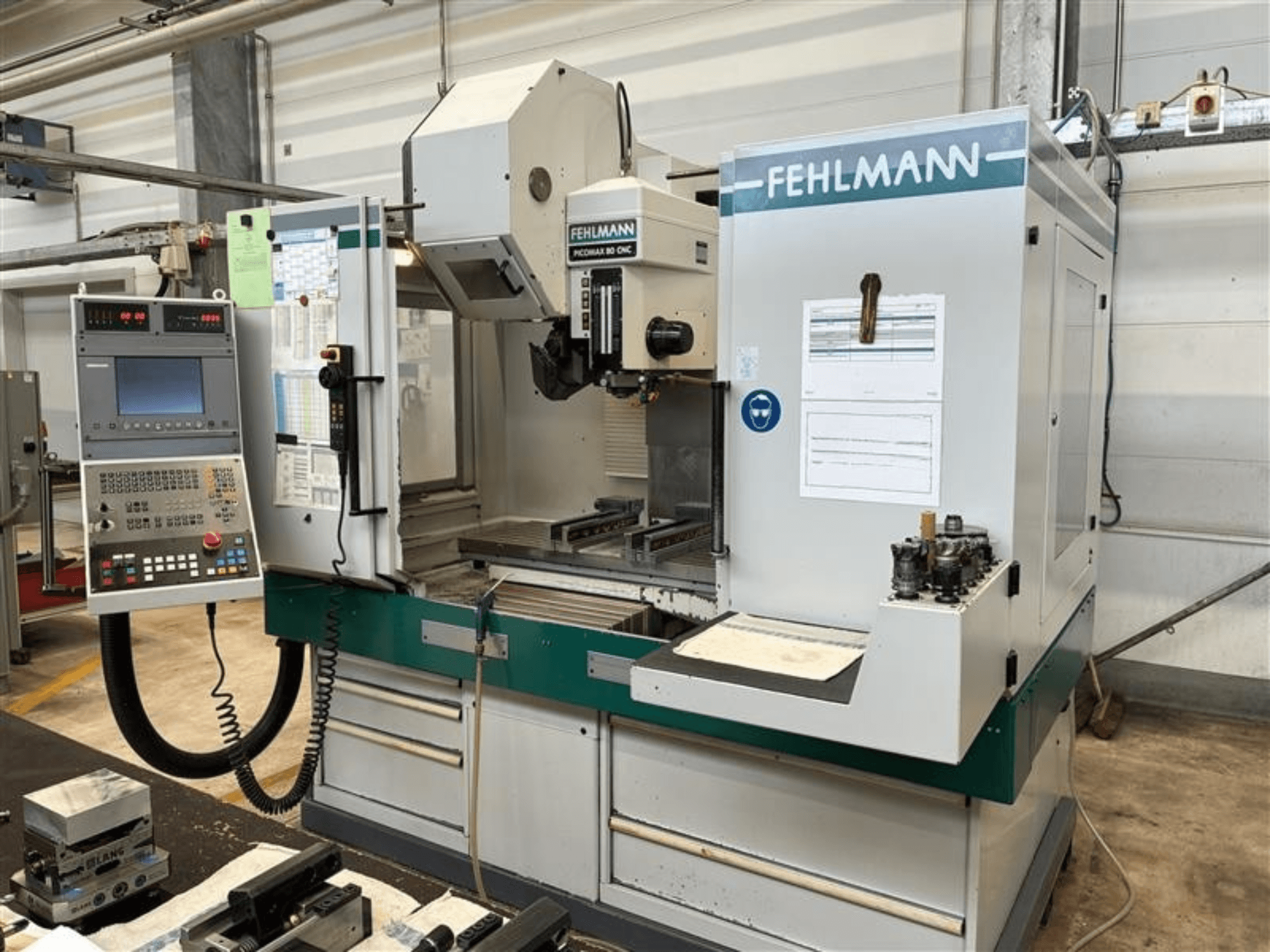 Вертикальный обрабатывающий центр FEHLMANN PICOMAX 80 CNC-W 2/3, вид спереди, с панелью управления и рабочей зоной.