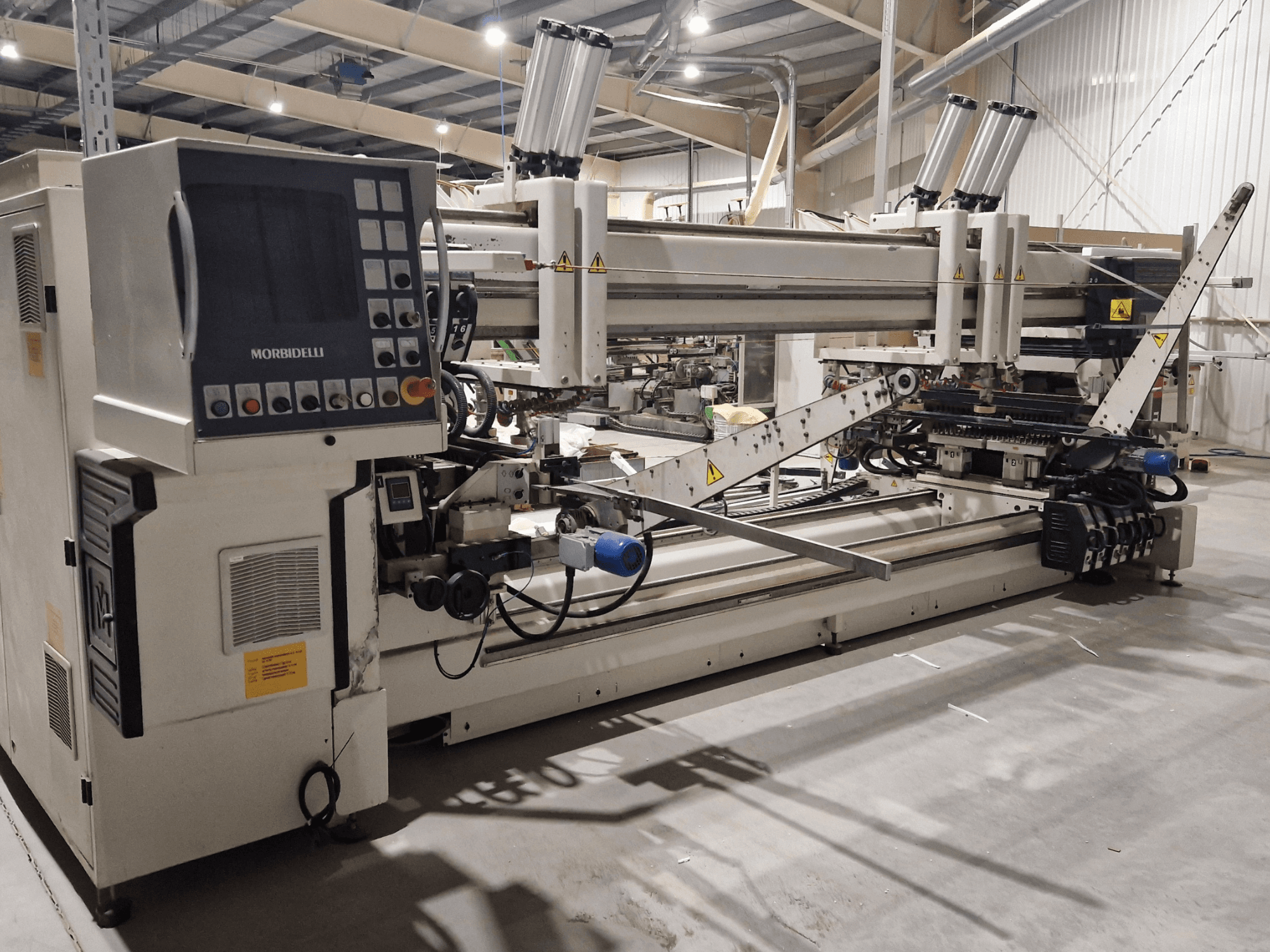 Многошпиндельный сверлильный станок SCM Morbidelli Zenith F2, вид сбоку, демонстрирующий панель управления и механические компоненты в мастерской.