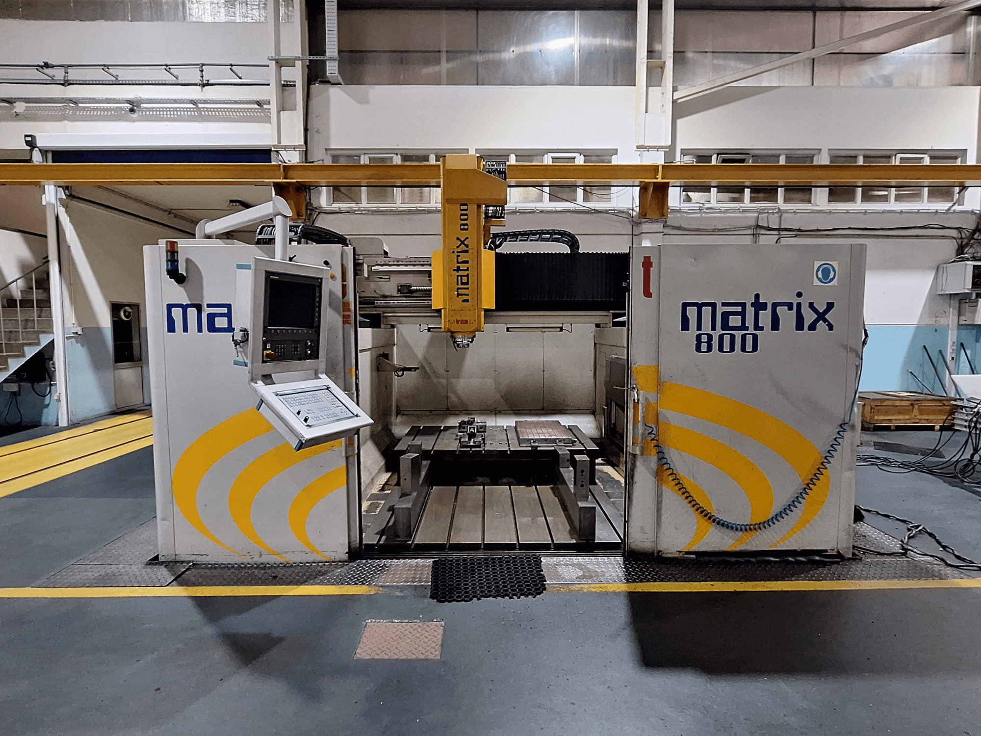 Портальный фрезерный станок Breton Matrix WM 800 K25 в мастерской, вид спереди на панель управления и рабочий стол.