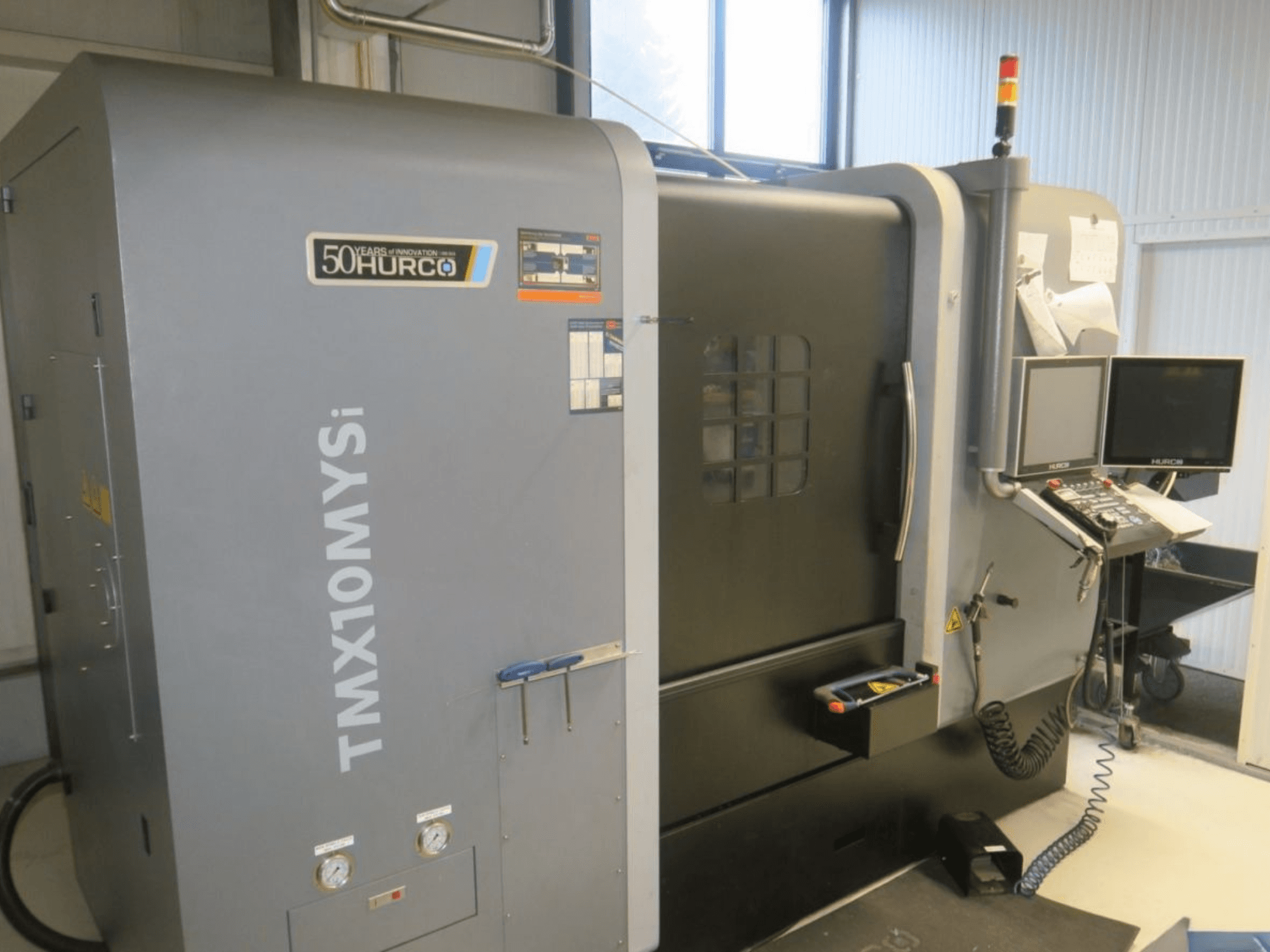 Станок с ЧПУ Hurco TMX10MYSi вид сбоку; панель управления, аварийное освещение и индикаторы.