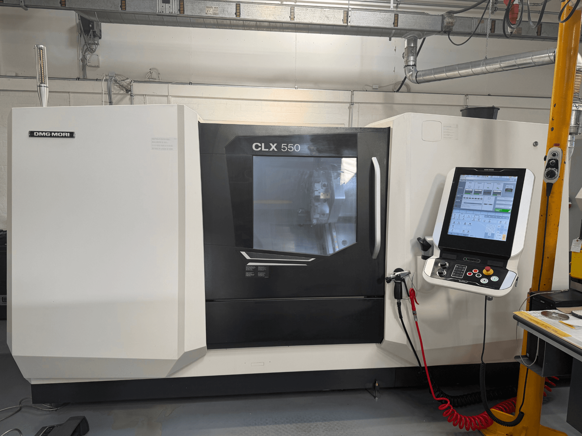 Горизонтальный токарный станок DMG MORI CLX 550 V4, вид спереди с панелью управления и дисплеем, демонстрирующий передовые возможности обработки.