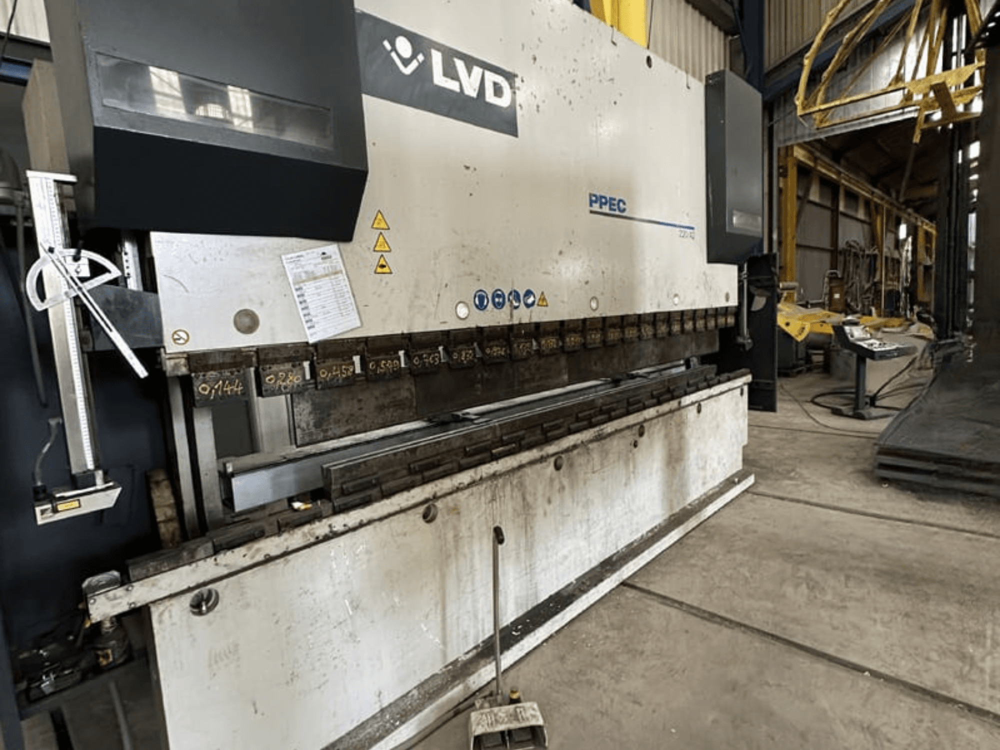 Гибочный пресс LVD PPEC 220/42 в боковом виде с панелью управления и измерительными метками, видимыми на станке.