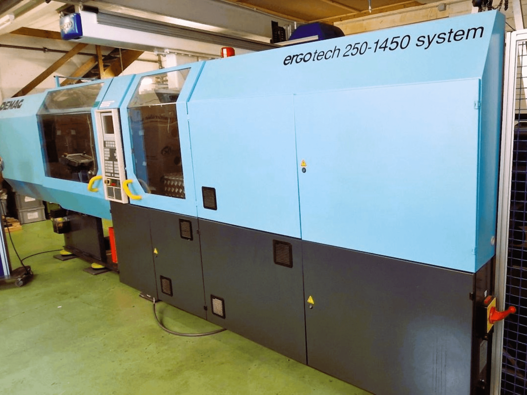 Системный термопластавтомат Ergotech 250-1450, вид спереди, цвет синий и черный, видна панель управления и элементы безопасности.