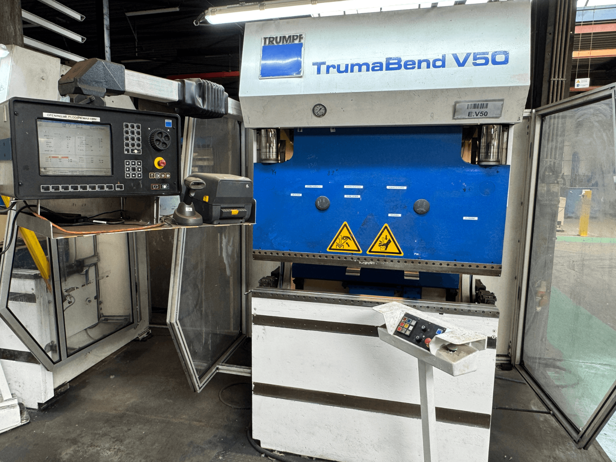 Листогибочный пресс TRUMPF TrumaBend V50 спереди, панель управления, предупреждения о безопасности и ярко выраженный сине-белый дизайн.