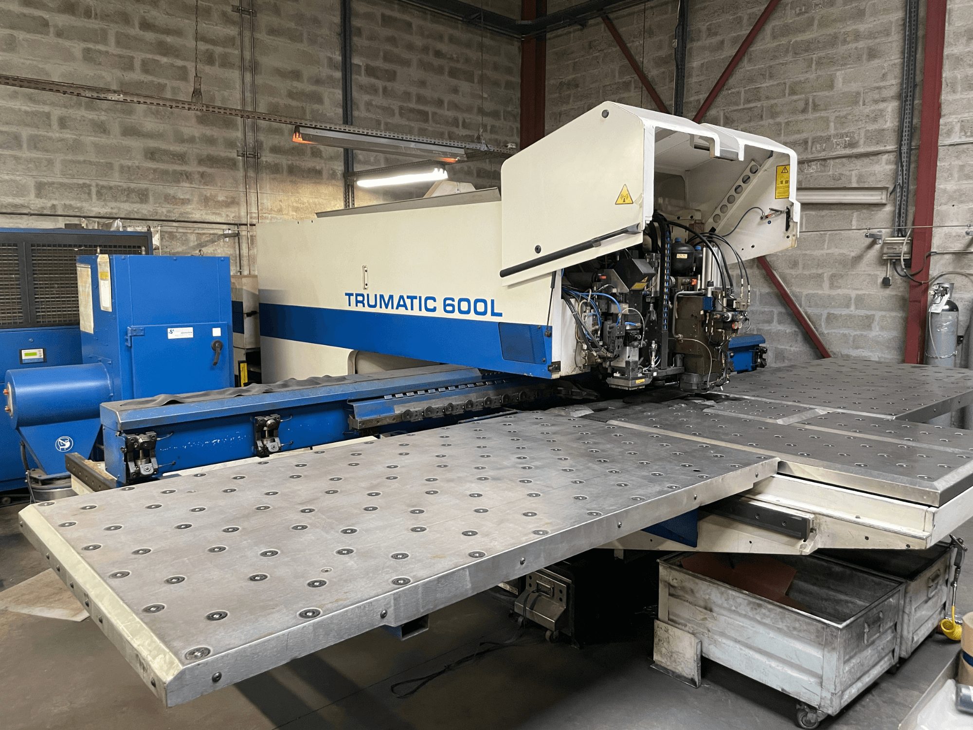 Станок лазерной резки CO2 TRUMPF TRUMATIC TC 600L, вид спереди, виден стол для резки металла и панель управления.