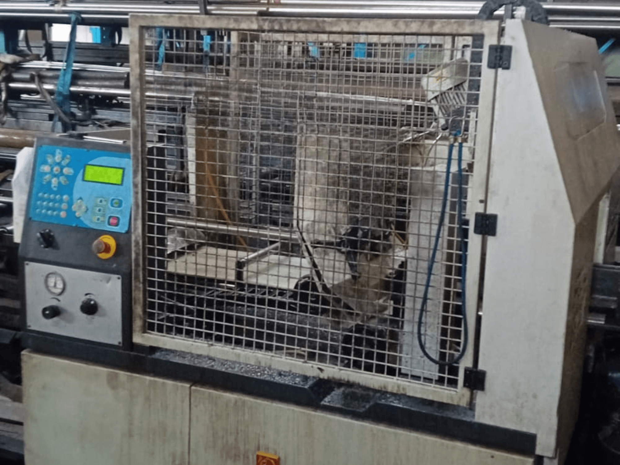 Ленточная пила по металлу Macc 381 AV, вид спереди, видна панель управления, защитный кожух и обломки металлоконструкций на основании.