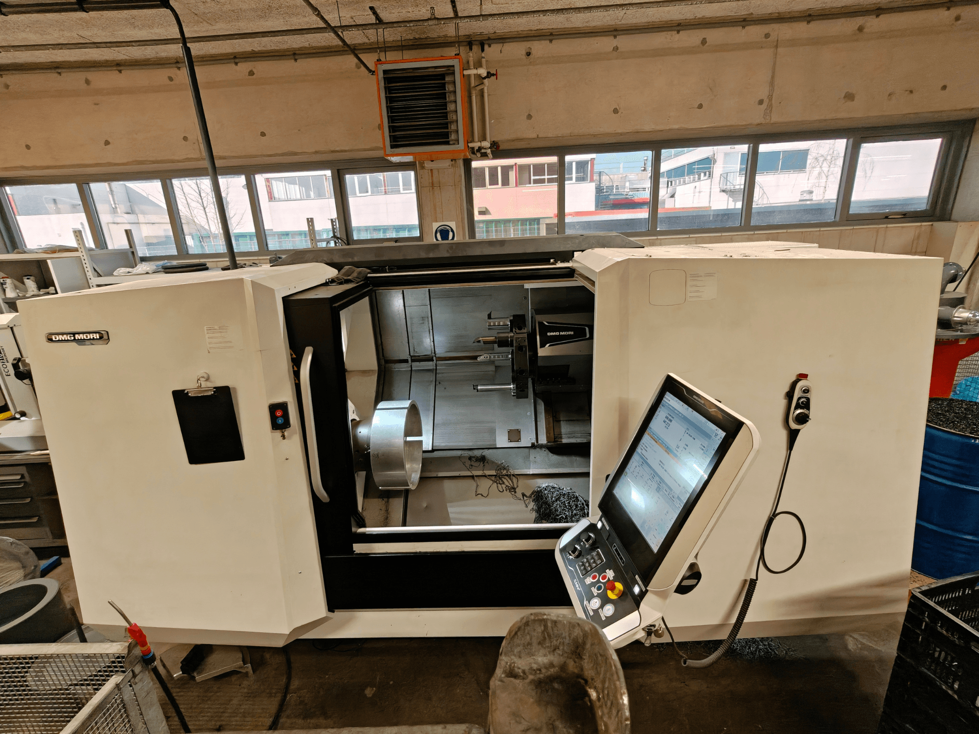 Вид спереди горизонтального токарного станка DMG MORI CLX 550, демонстрирующий панель управления и открытую рабочую зону.