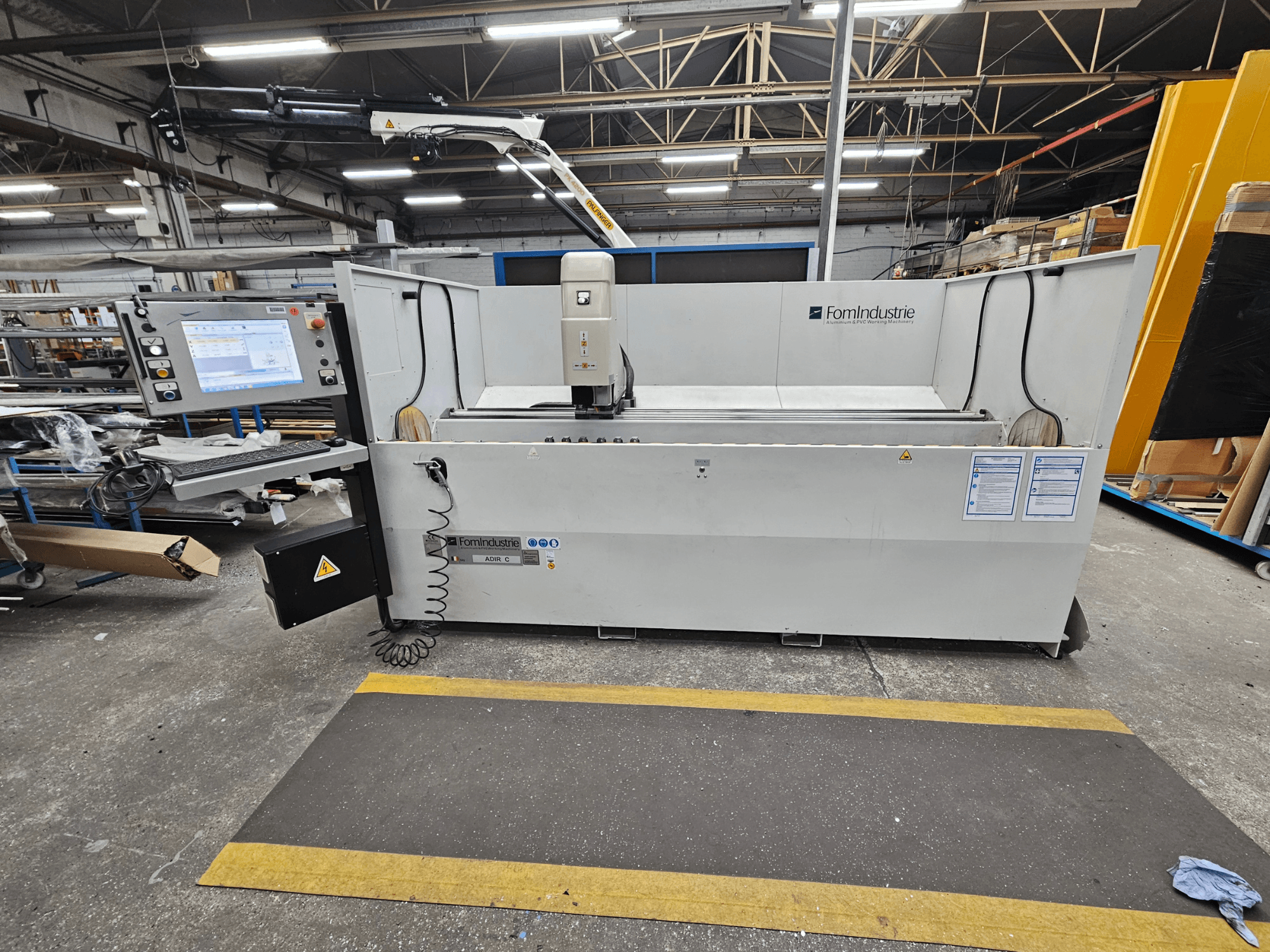 Вертикальный обрабатывающий центр FomIndustrie ADIR C в мастерской, вид спереди на панель управления и детали станка.