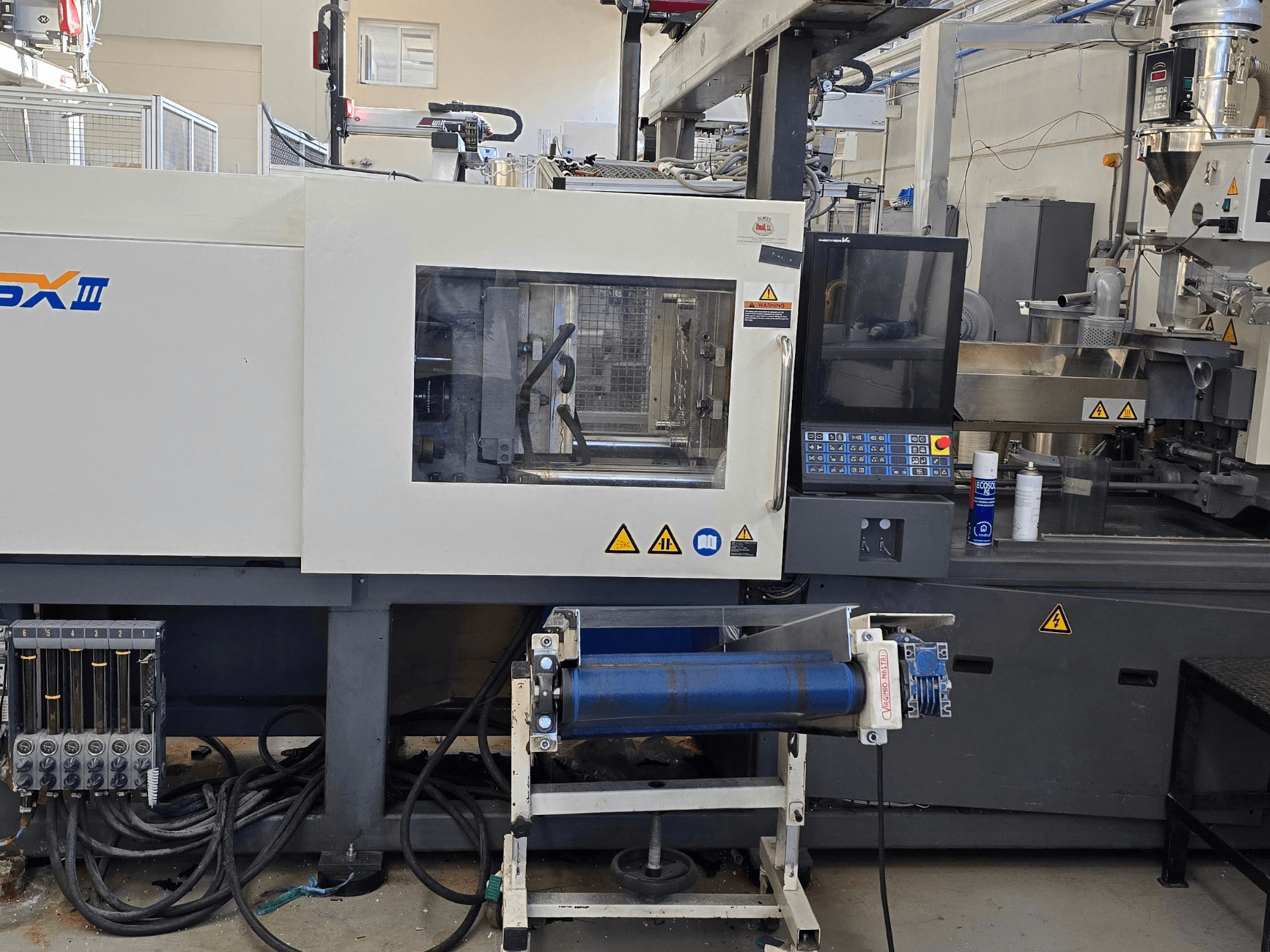 Электрическая машина для литья под давлением SHIBAURA EC130SXIII-4A, вид спереди, демонстрирует панель управления и гидравлические компоненты.