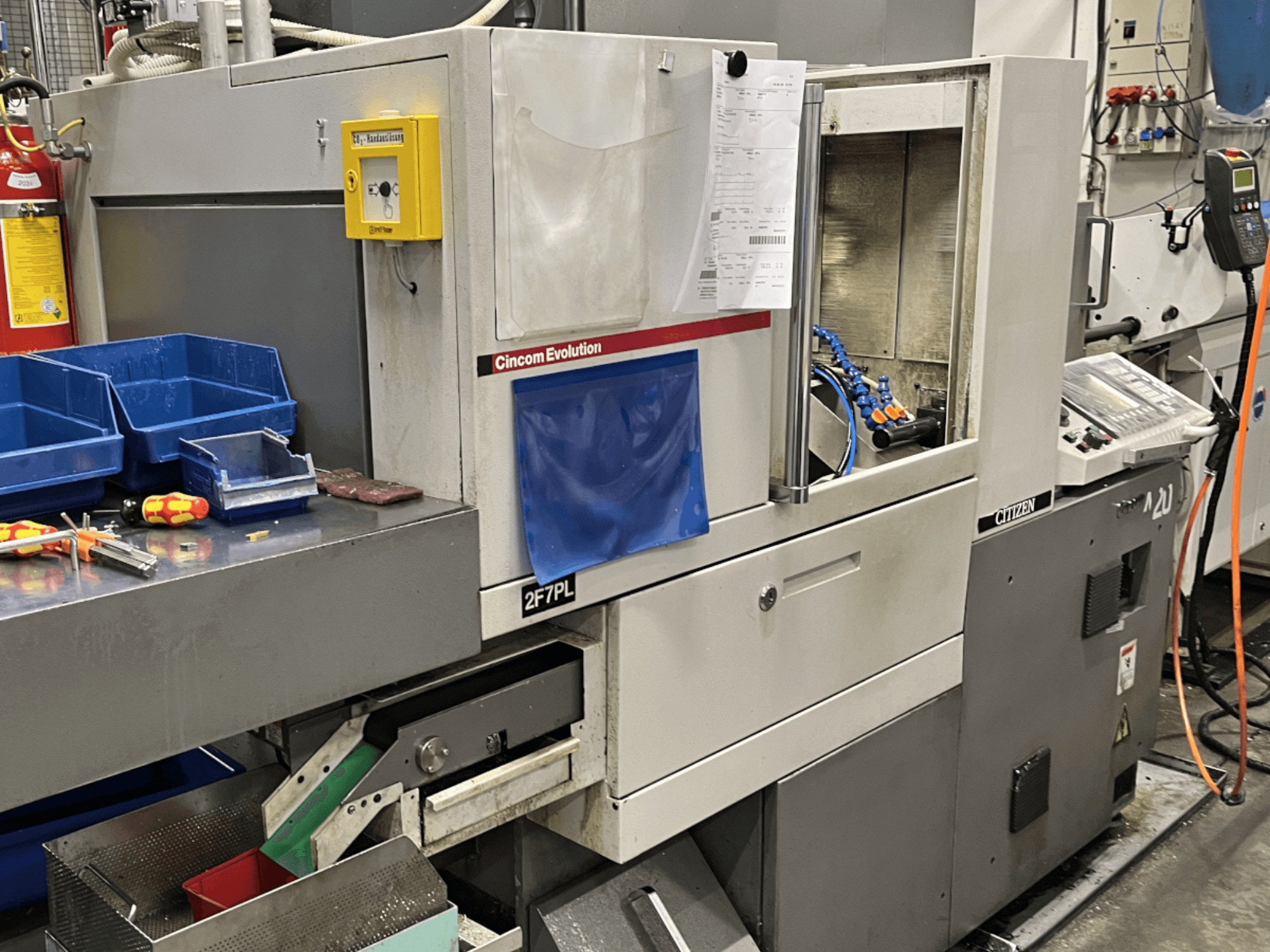 Обрабатывающий центр Cincom Evolution 2F7PL, вид спереди; элементы управления, корзины для инструментов и подробная панель управления.