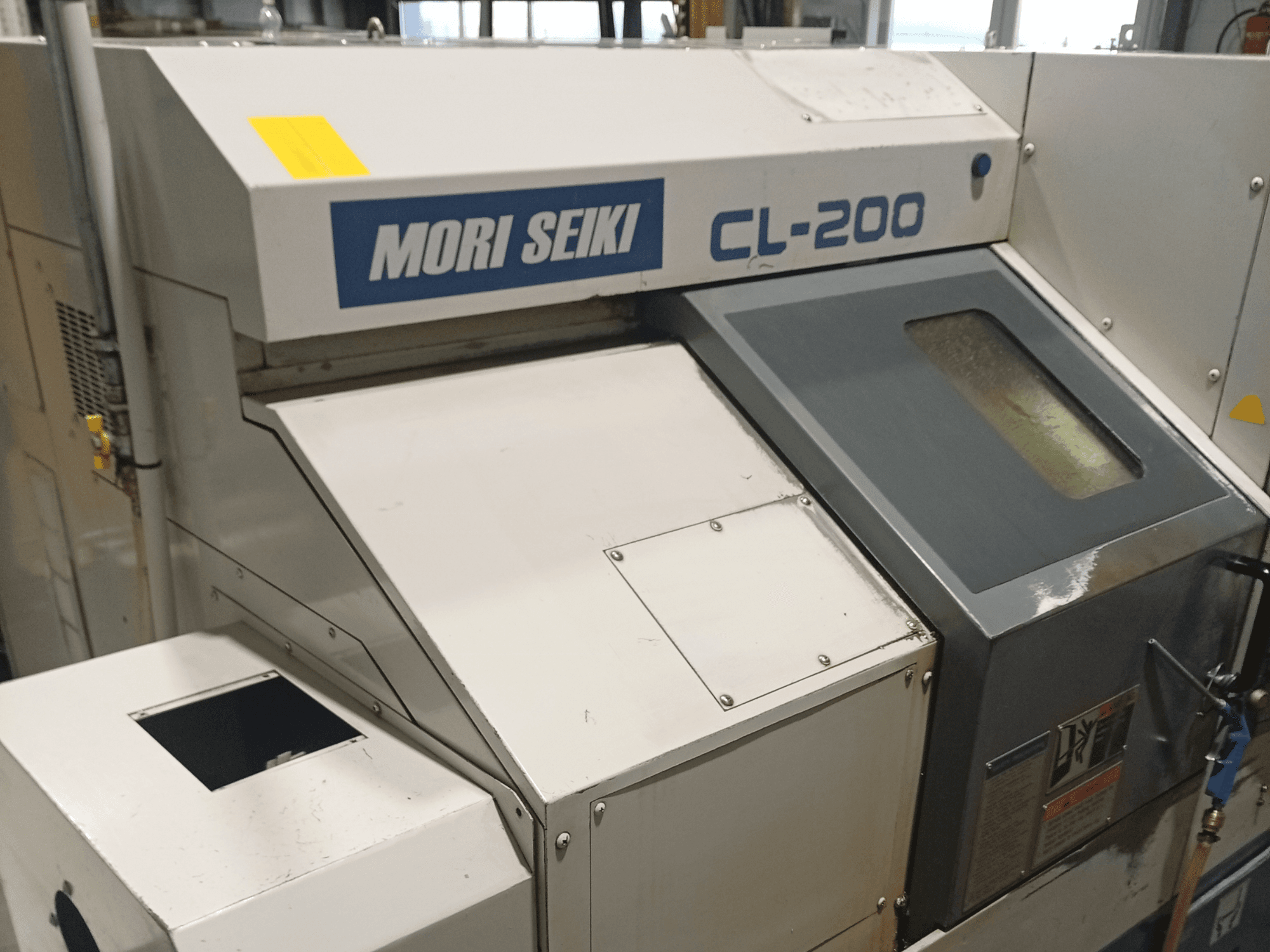 Горизонтальный токарный станок DMG Mori Seiki CL-200B, вид спереди с изображением панели управления и деталей окна для подачи охлаждающей жидкости.