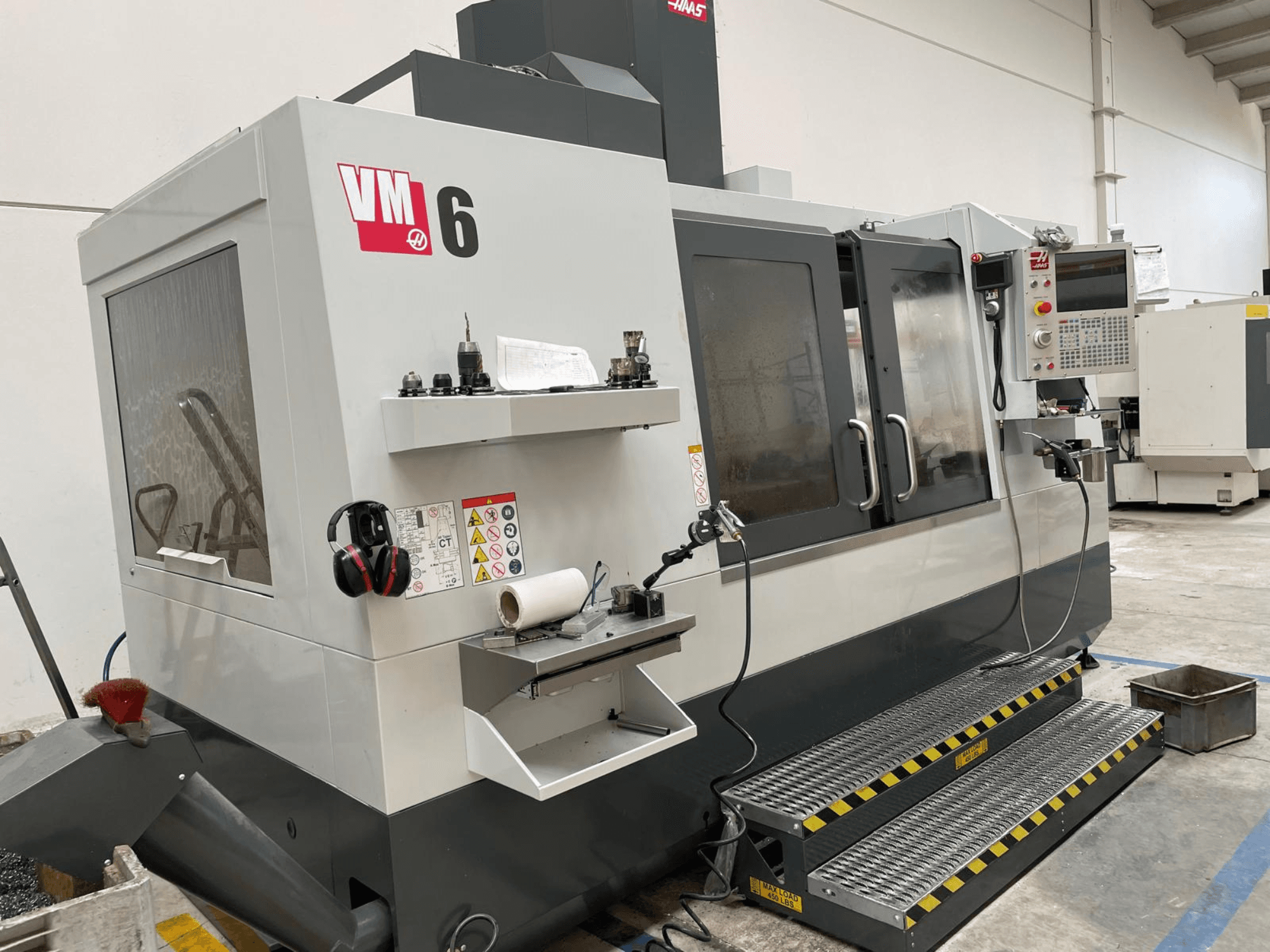 Вертикальный обрабатывающий центр Haas VM-6, вид спереди: панель управления, держатели инструментов и элементы безопасности.