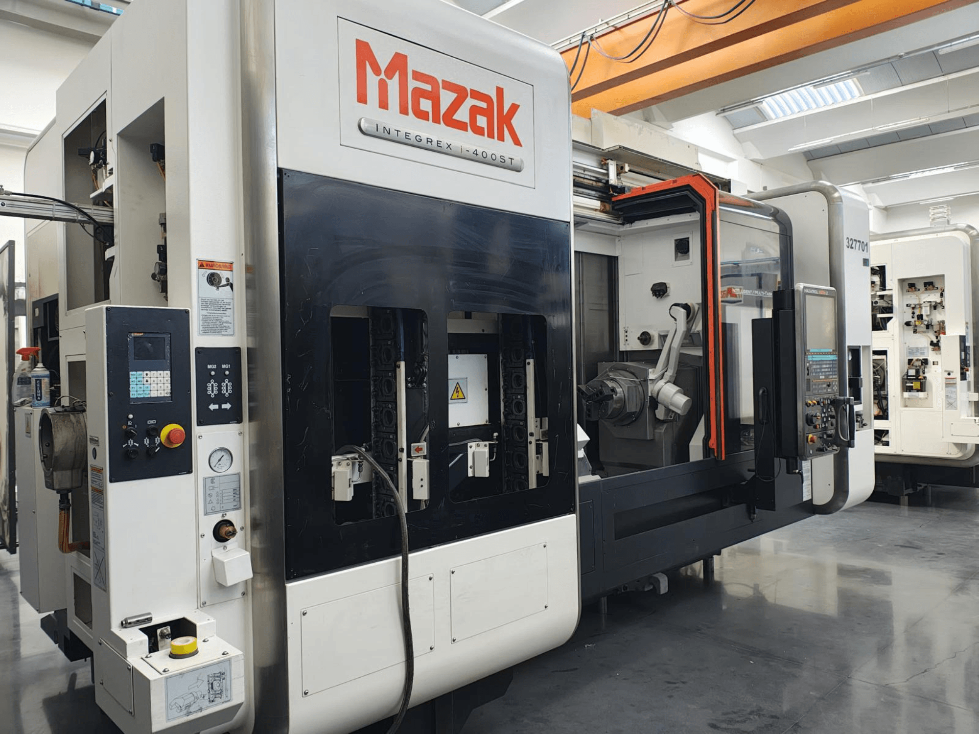 Mazak Integrex 400ST, вид спереди; станок с ЧПУ с панелью управления, шпинделями и роботизированной рукой виден в мастерской.