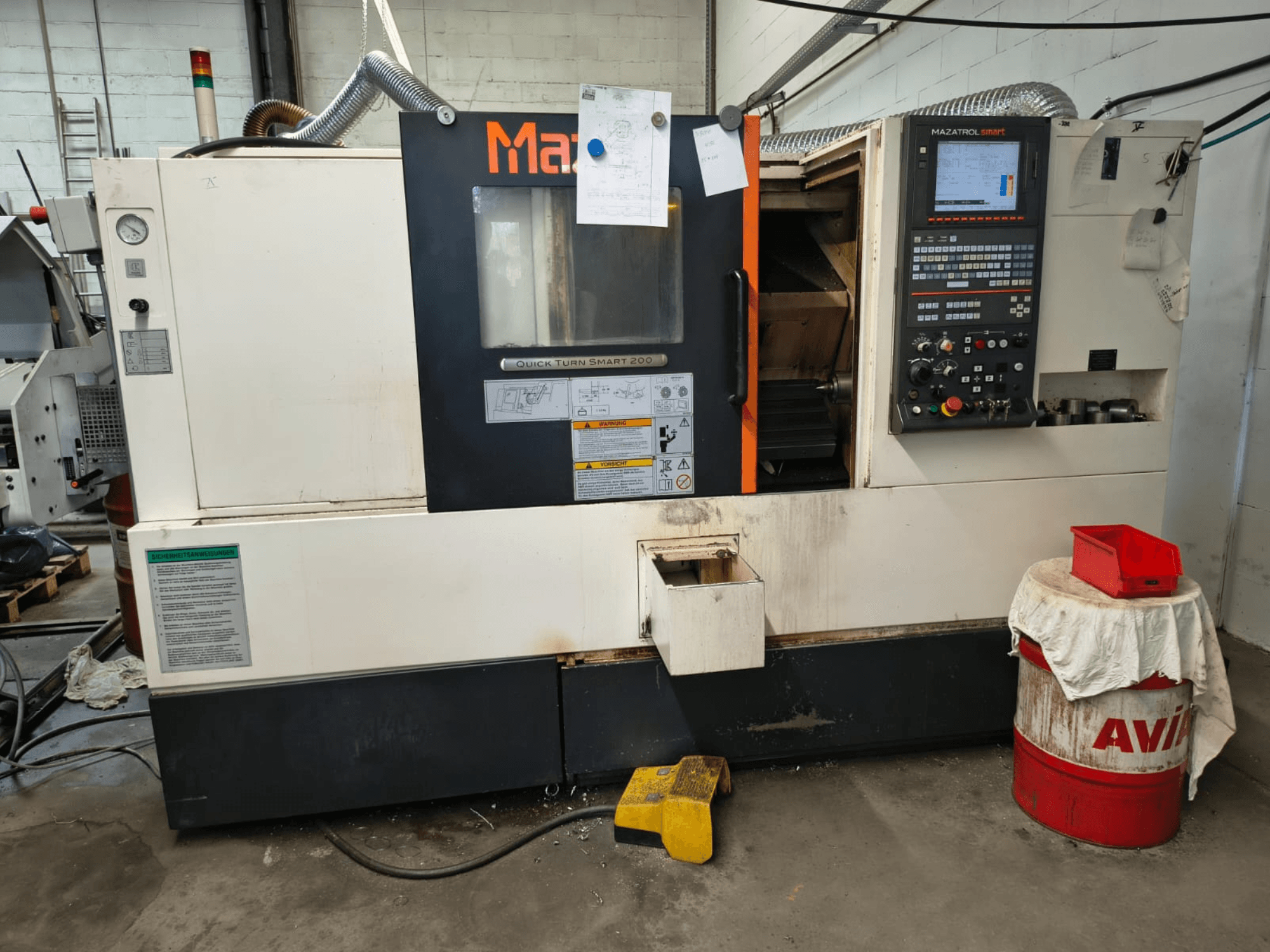 Mazak Quick Turn Smart 200, горизонтальный токарный станок, вид спереди с панелью управления, баком для охлаждающей жидкости и видимыми маркировками.