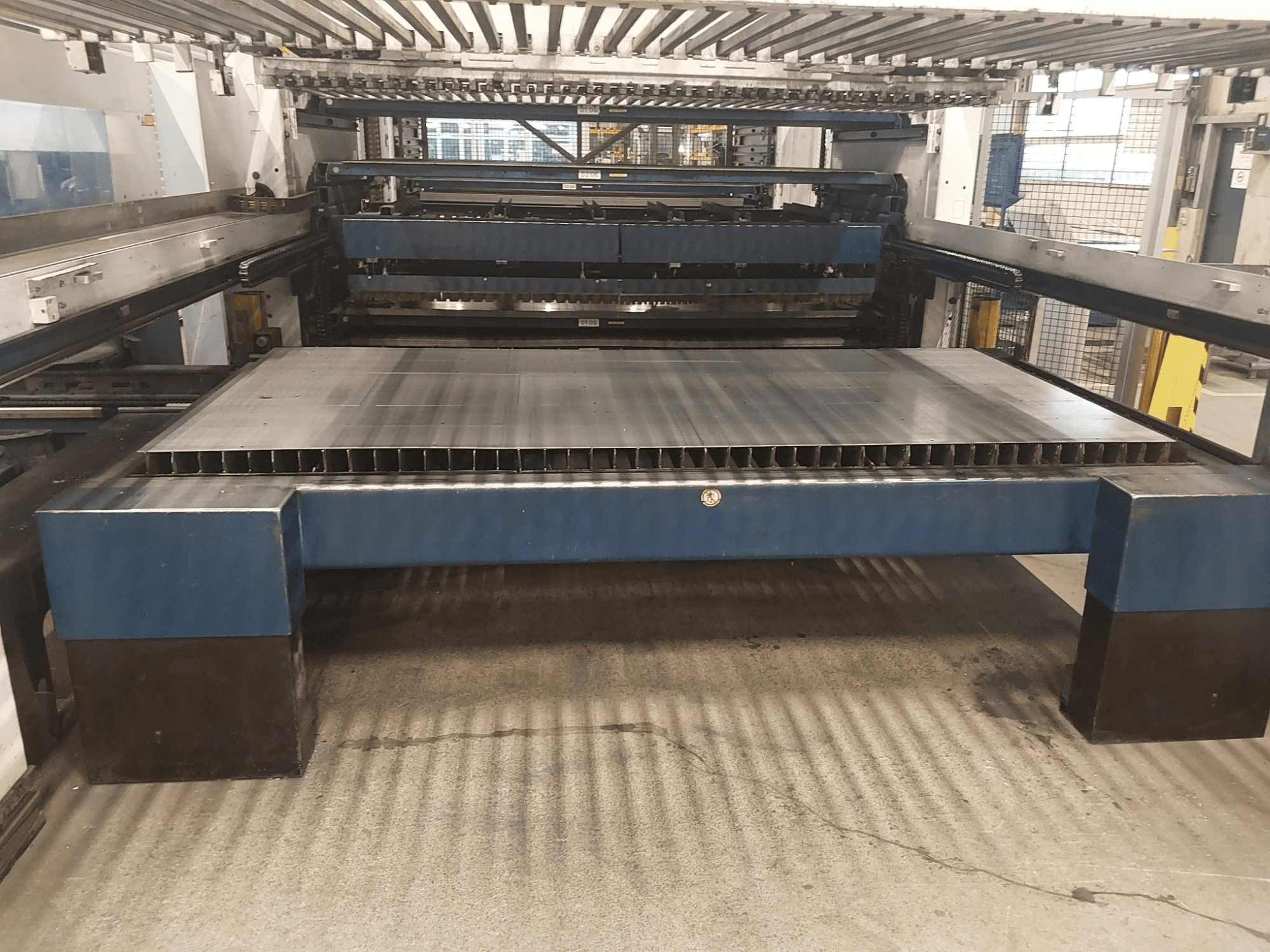 Вид спереди на станок лазерной резки CO2 TRUMPF TruLaser 3030 L20 с большой режущей станиной и опорной конструкцией.