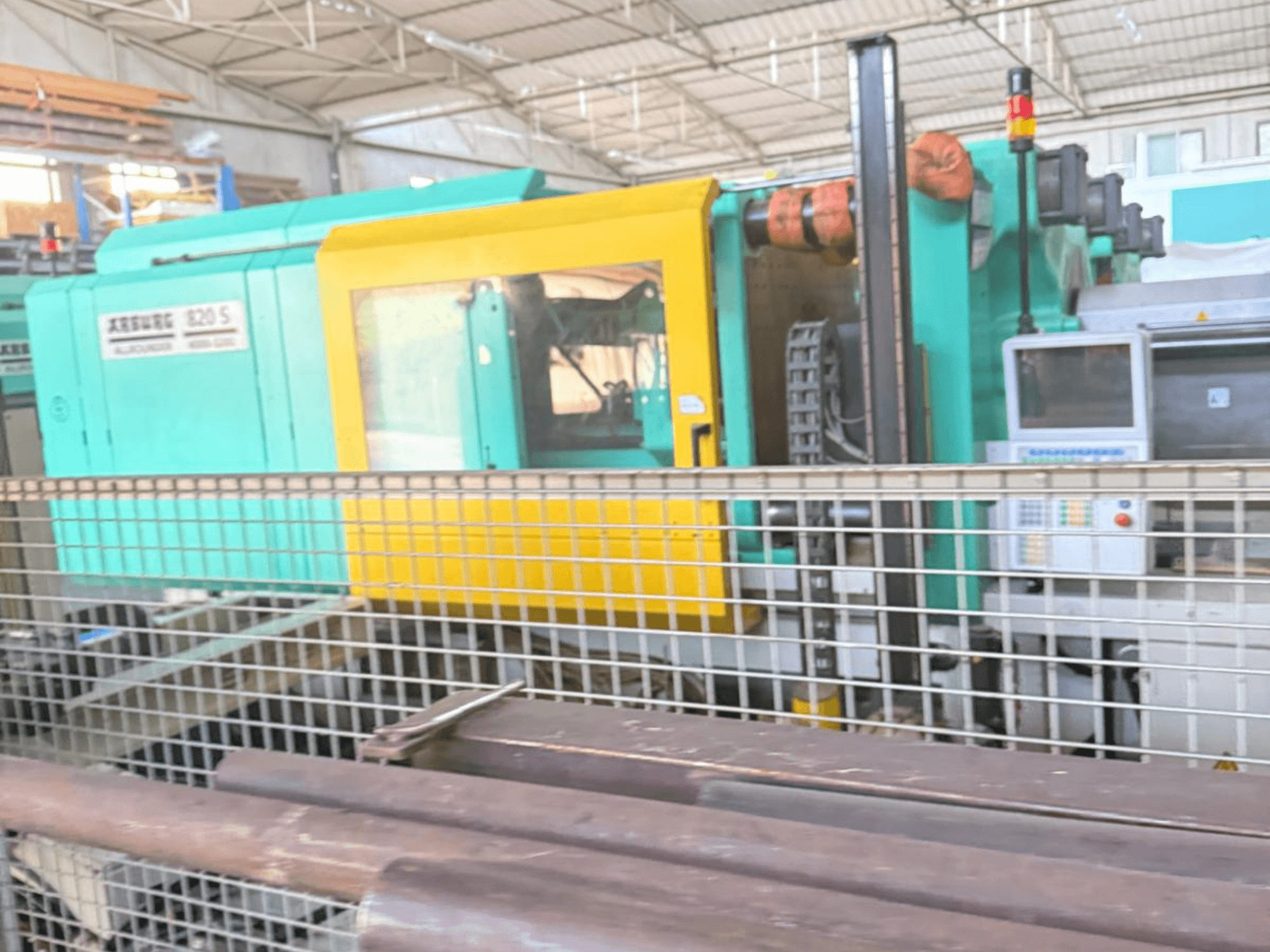 Гидравлическая машина для литья под давлением Arburg SELECTA 820 S 4000-3200, вид сбоку, демонстрирует панель управления и яркий желто-телесный дизайн.