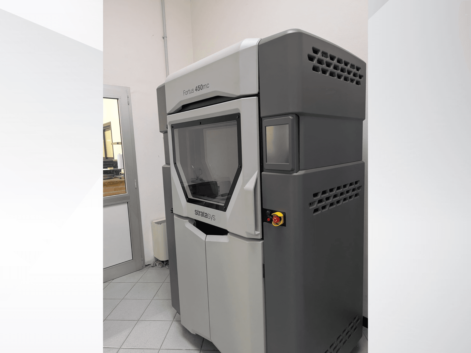 Пластиковый 3D-принтер Stratasys FORTUS 450mc на виде сбоку, демонстрирующий элегантный дизайн и панель управления.
