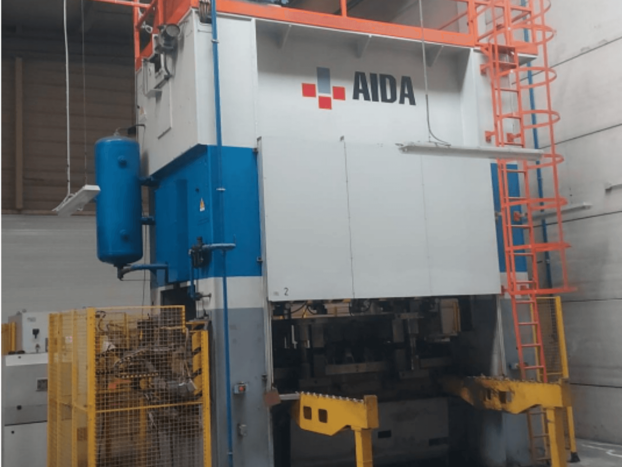 Механический штамповочный пресс AIDA 315/2MR/LD/TE 3, вид спереди с сине-белым корпусом, желтым основанием и защитной клеткой.