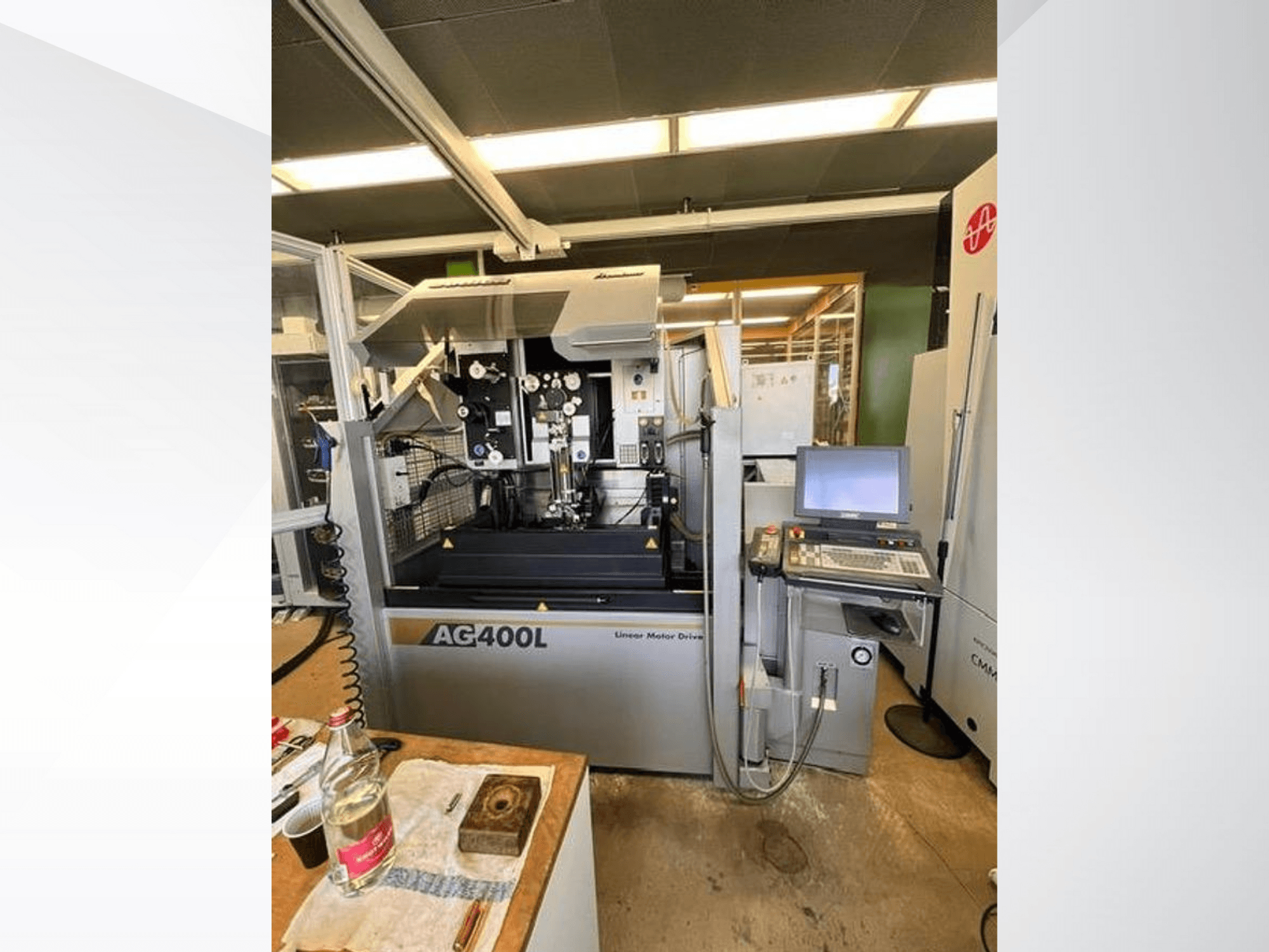 Станок с линейным приводом AG400L, вид спереди, панель управления и рабочая зона с видимыми элементами безопасности.
