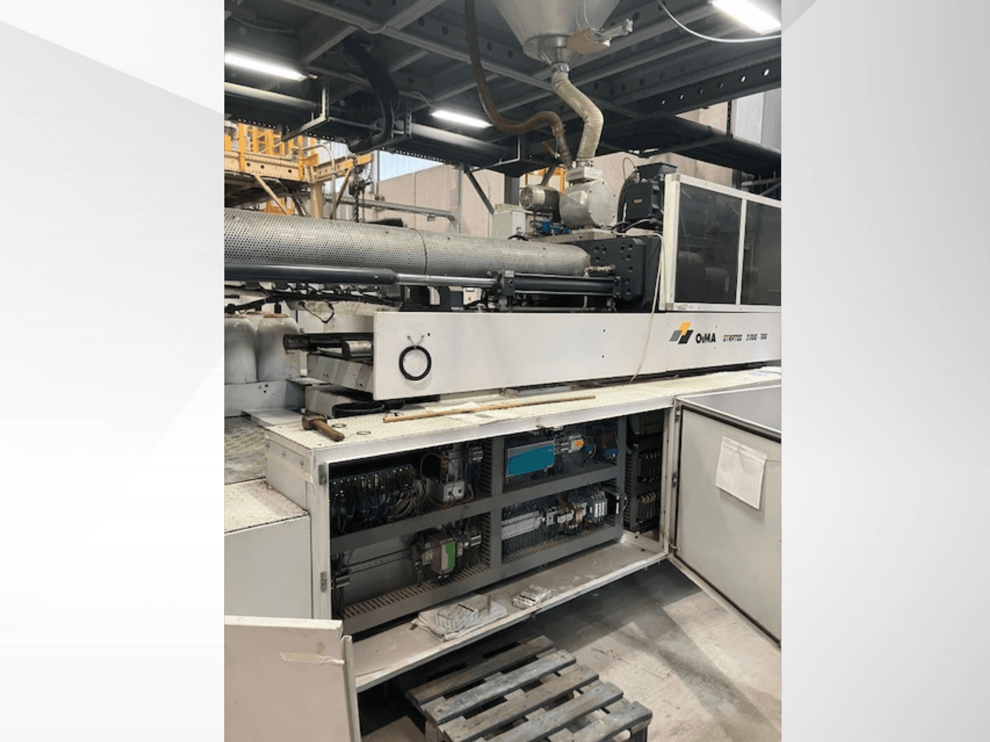 Вид спереди на экструдер OMA 3500, демонстрирующий рабочие части, панель управления и детали проводки. Тяжелая техника в промышленных условиях.