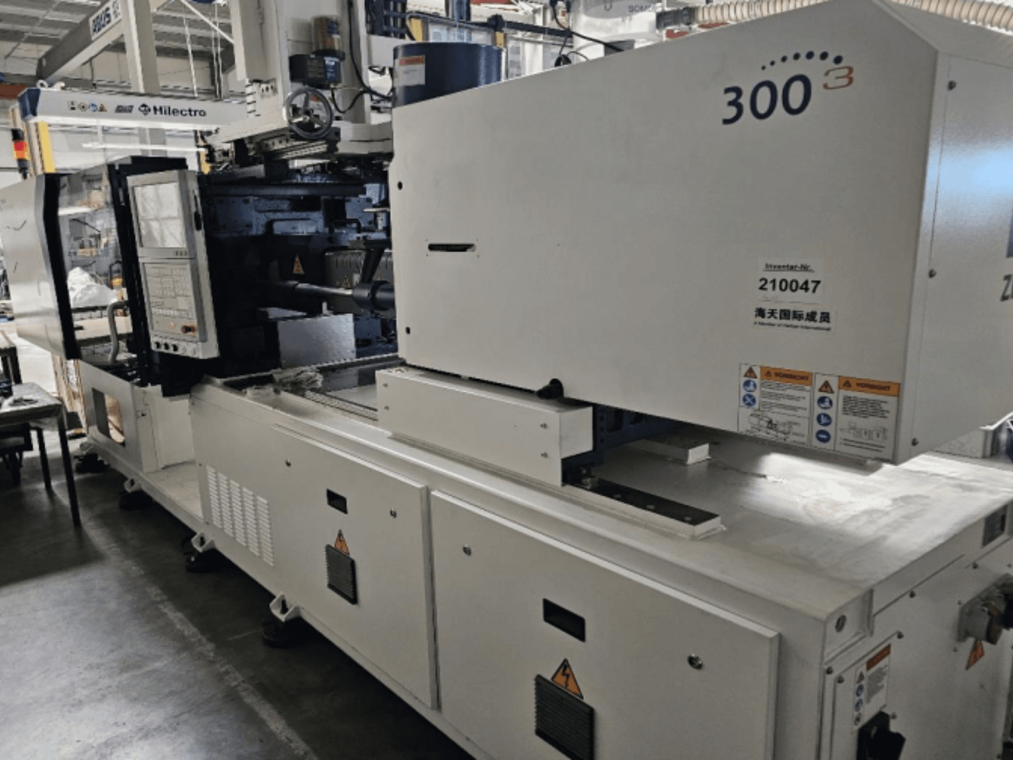 Машина для литья под давлением, марка Zhenjing, модель 300, вид спереди, видна панель управления и предупреждающие наклейки.