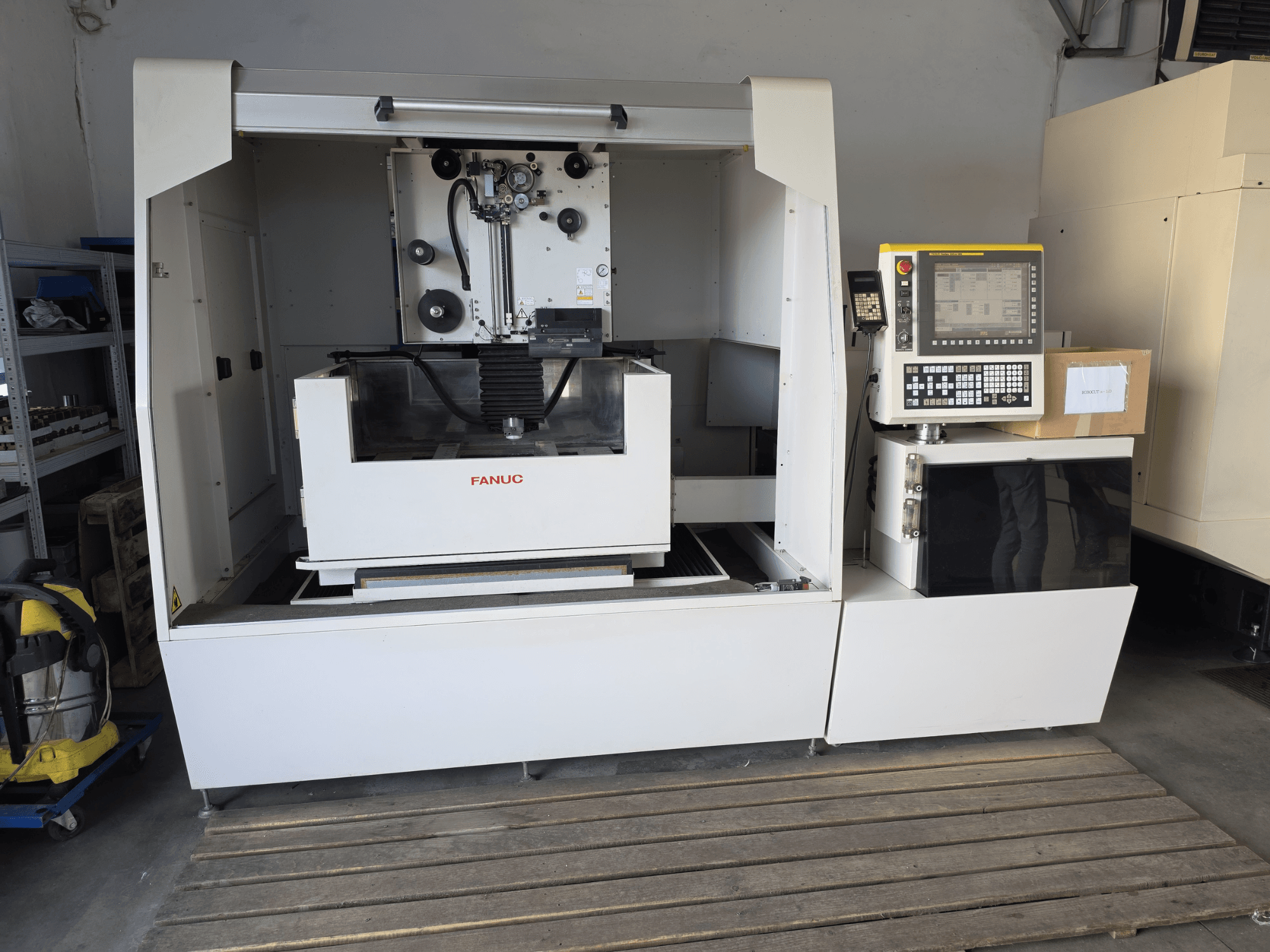 Электроэрозионный станок FANUC ROBOCUT alpha-1iD: вид спереди, на котором видны панель управления, рабочая зона и компактная конструкция в условиях цеха.