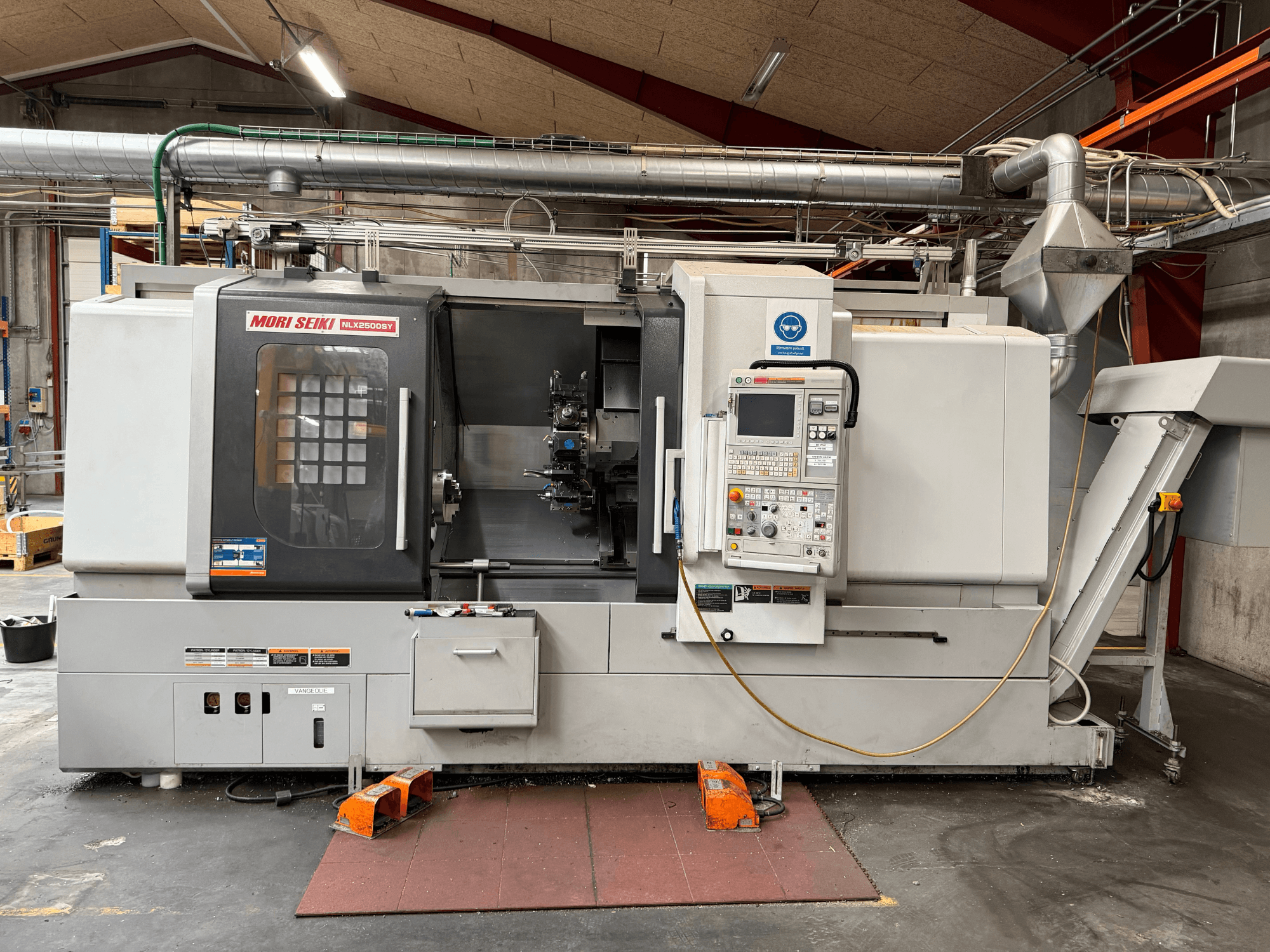 Горизонтальный токарный станок DMG MORI NLX2500SY/1250, вид спереди, на котором видны панель управления и рабочие узлы.