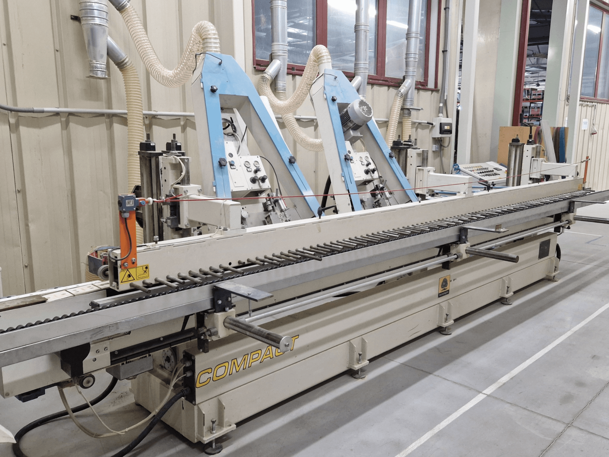 Ленточная шлифовальная машина TECNOLEGNO COMPACT 52 в мастерской, вид сбоку на панель управления и механизм шлифовальной ленты.