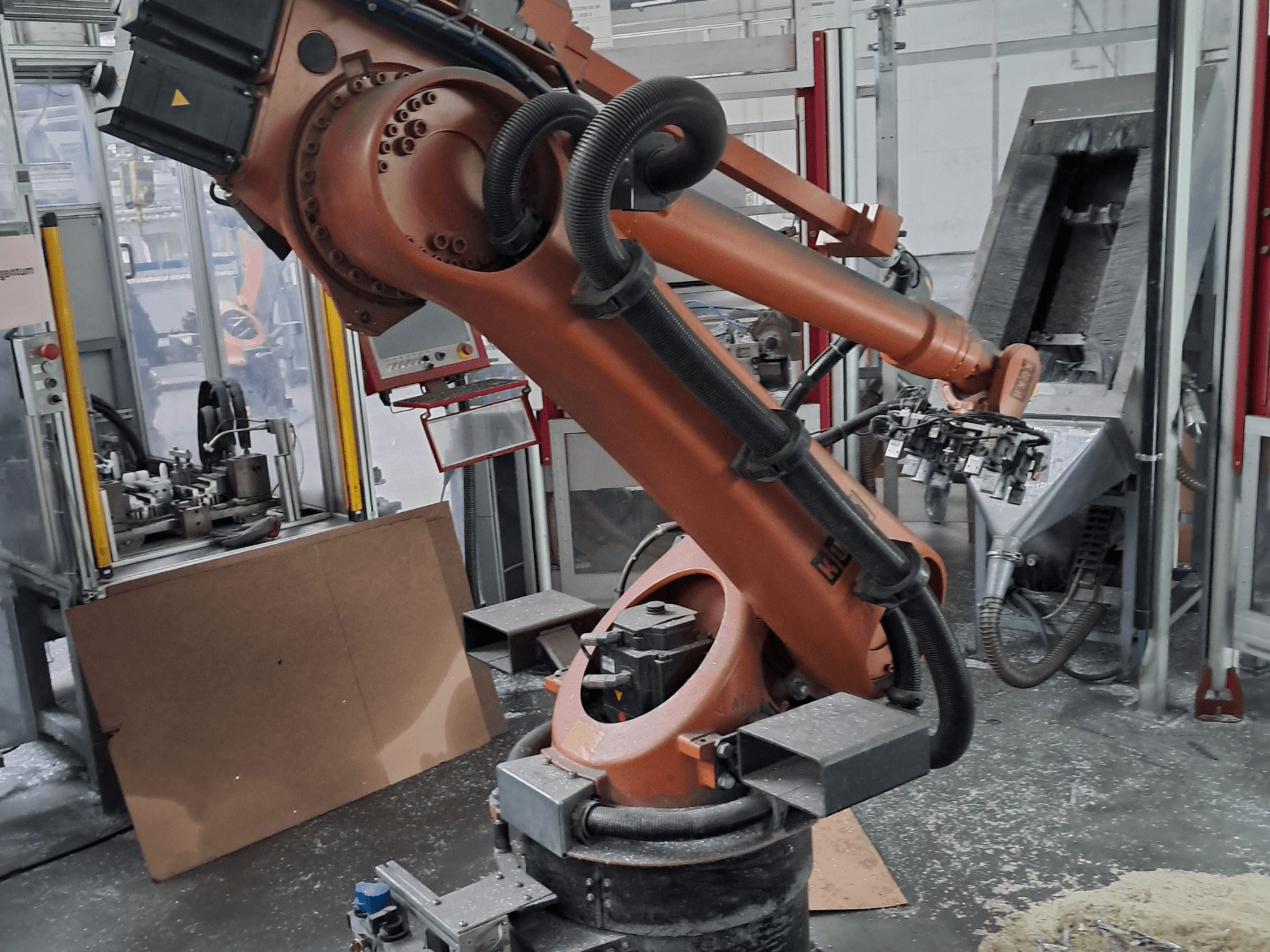 Роботизированный манипулятор KUKA KR 30 L 16-2 в цехе, вид спереди. Имеет шарнирные соединения и расположен на фоне промышленного рабочего пространства.
