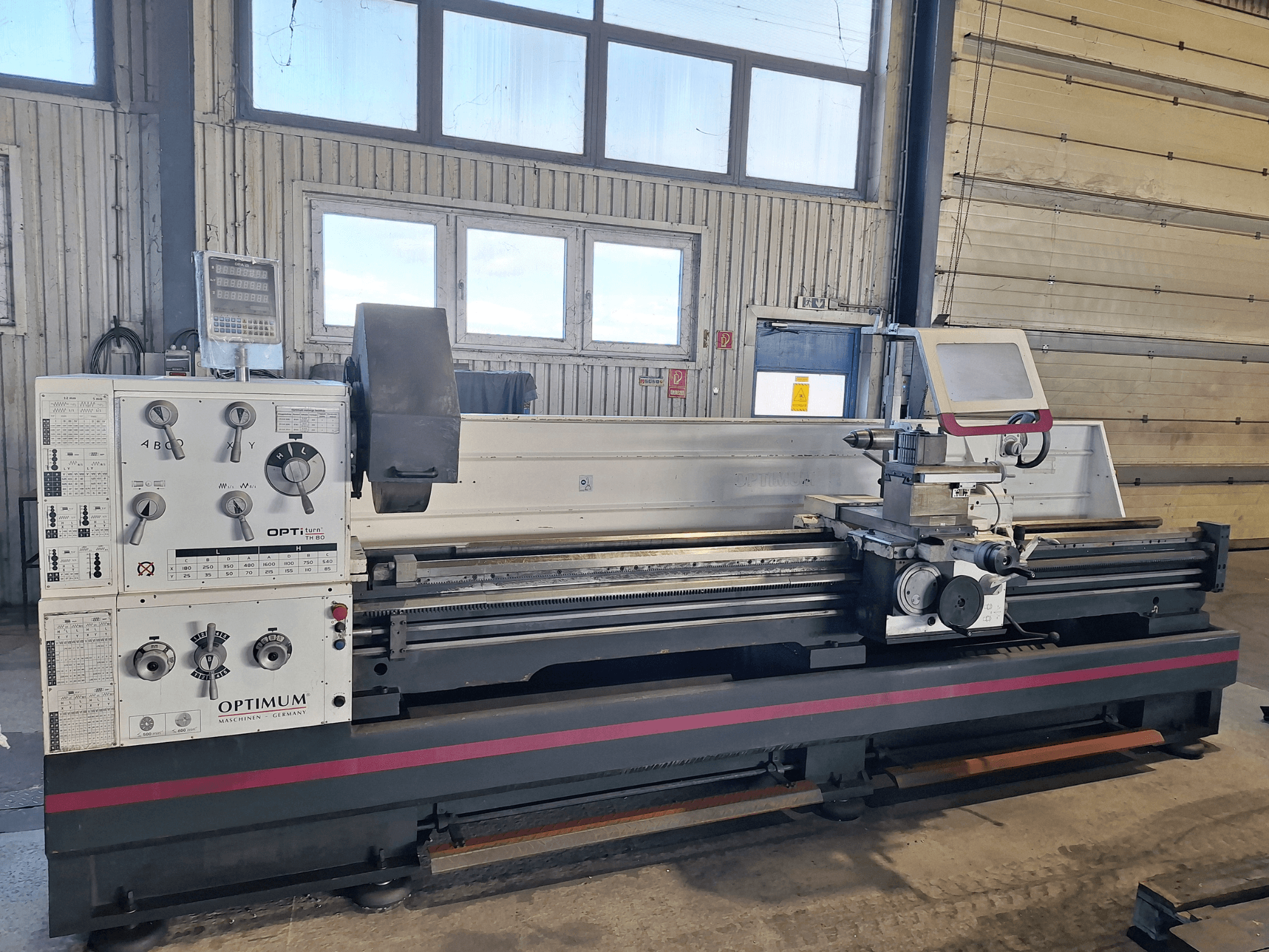 Горизонтальный токарный станок Optimum OptiTurn TH 8030D на виде сбоку, с панелью управления, держателем инструмента и прочным основанием.