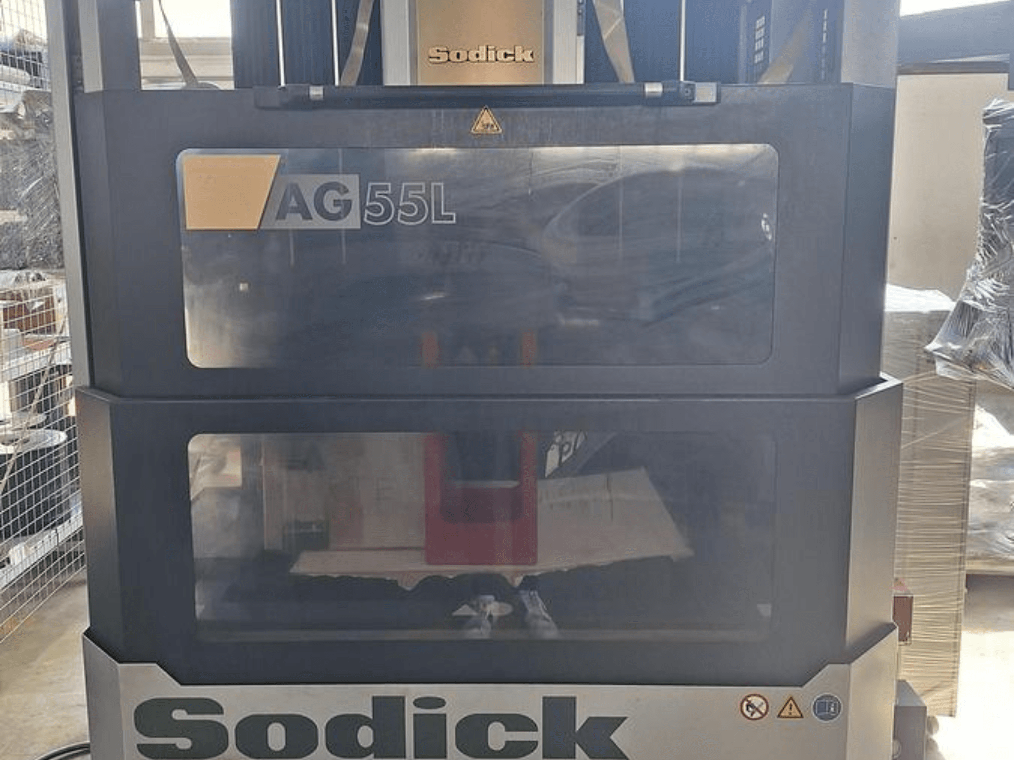 Станок Sodick AG 55L Die-Sinking EDM Machine, вид спереди, элементы управления видны через прозрачные панели, демонстрирующие рабочее пространство внутри.