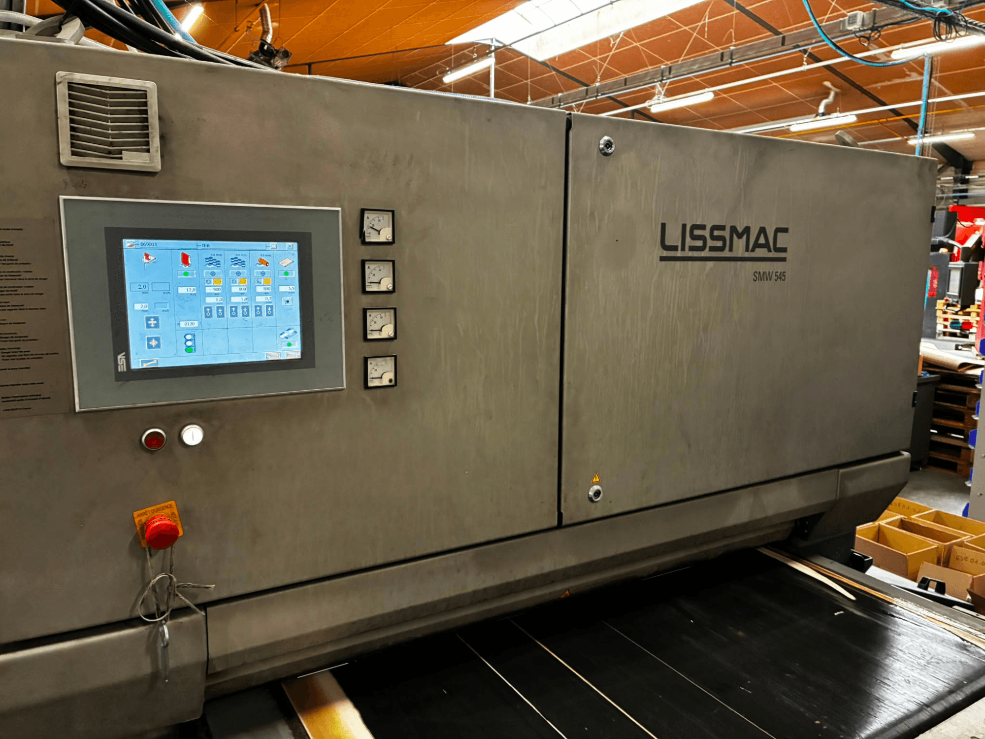 Машина для удаления заусенцев LISSMAC SMW 545 RTTB в виде сбоку, оснащённая панелью управления с сенсорным экраном и приборами.