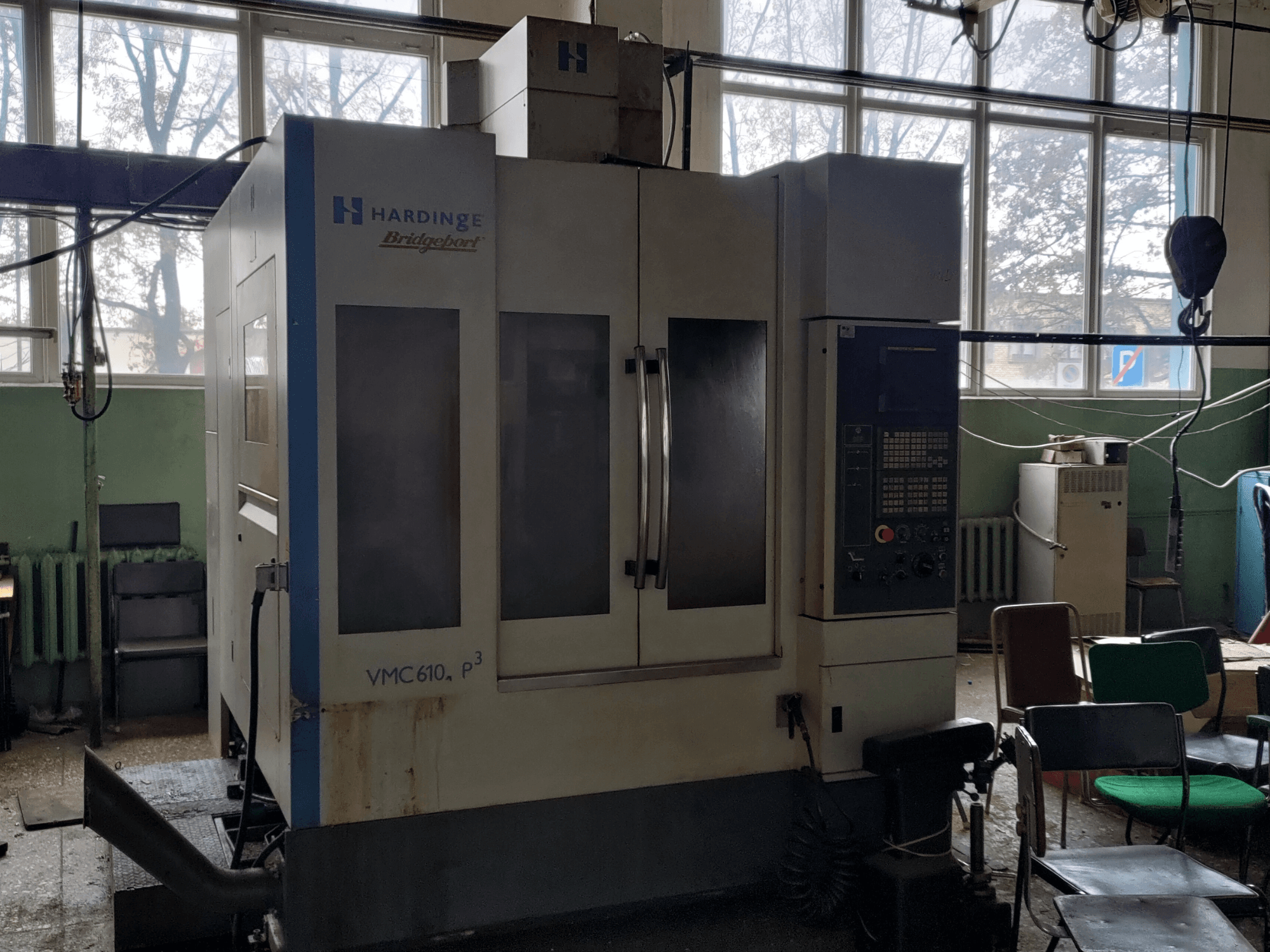 Вертикальный обрабатывающий центр Bridgeport VMC-610 XP3, вид спереди, на котором видны панель управления и большие стеклянные дверцы.