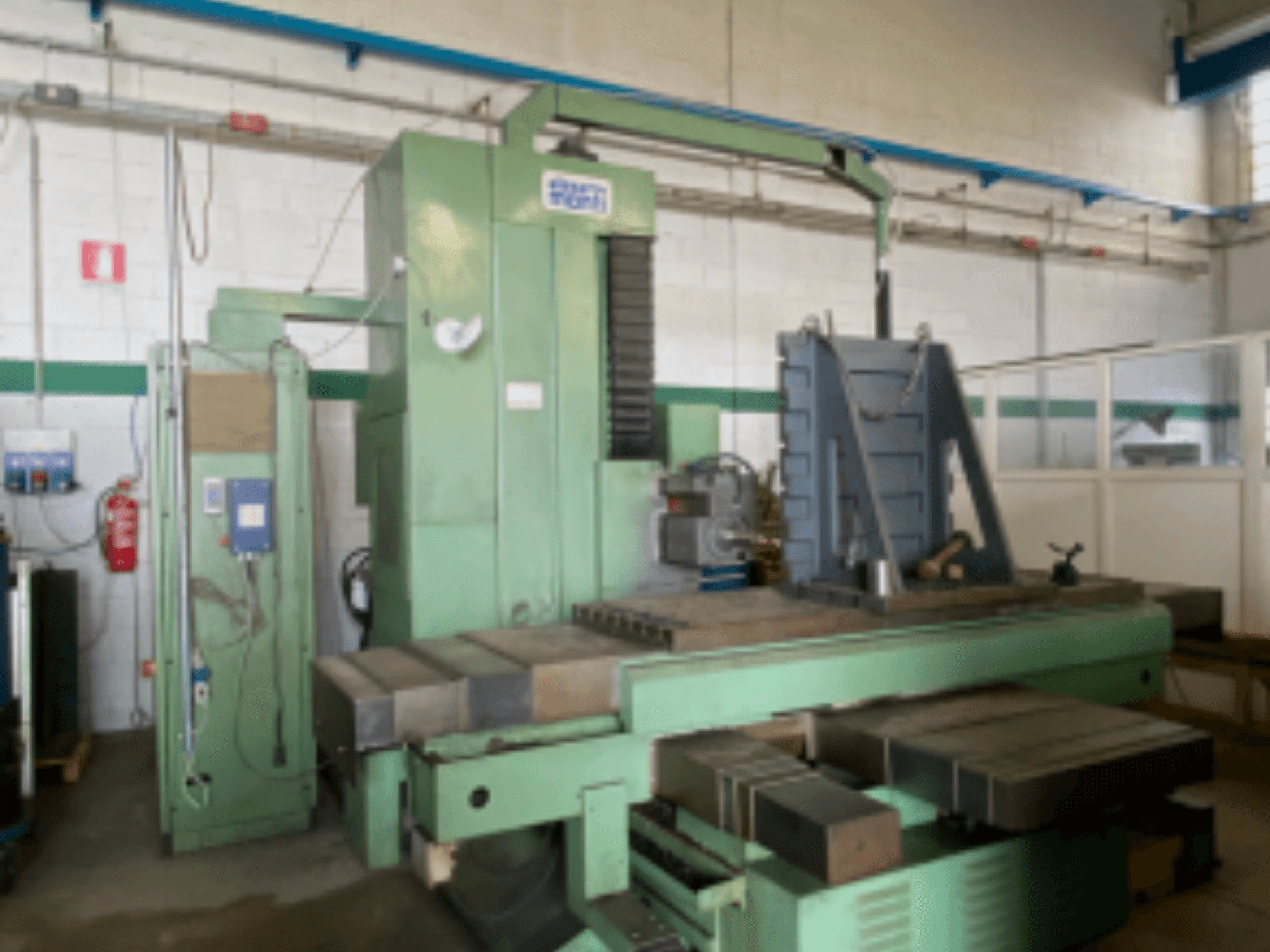 Горизонтальный обрабатывающий центр Alesa Monti MAF45 в мастерской, вид сбоку на панель управления и большой рабочий стол.