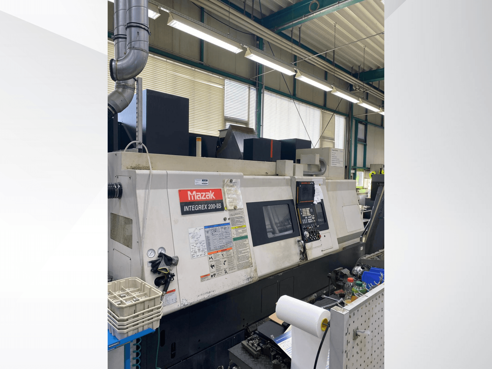 Токарно-фрезерный центр Mazak INTEGREX 200 III S, вид сбоку, на котором видны панель управления, измерительные приборы и инструменты в рабочей зоне.