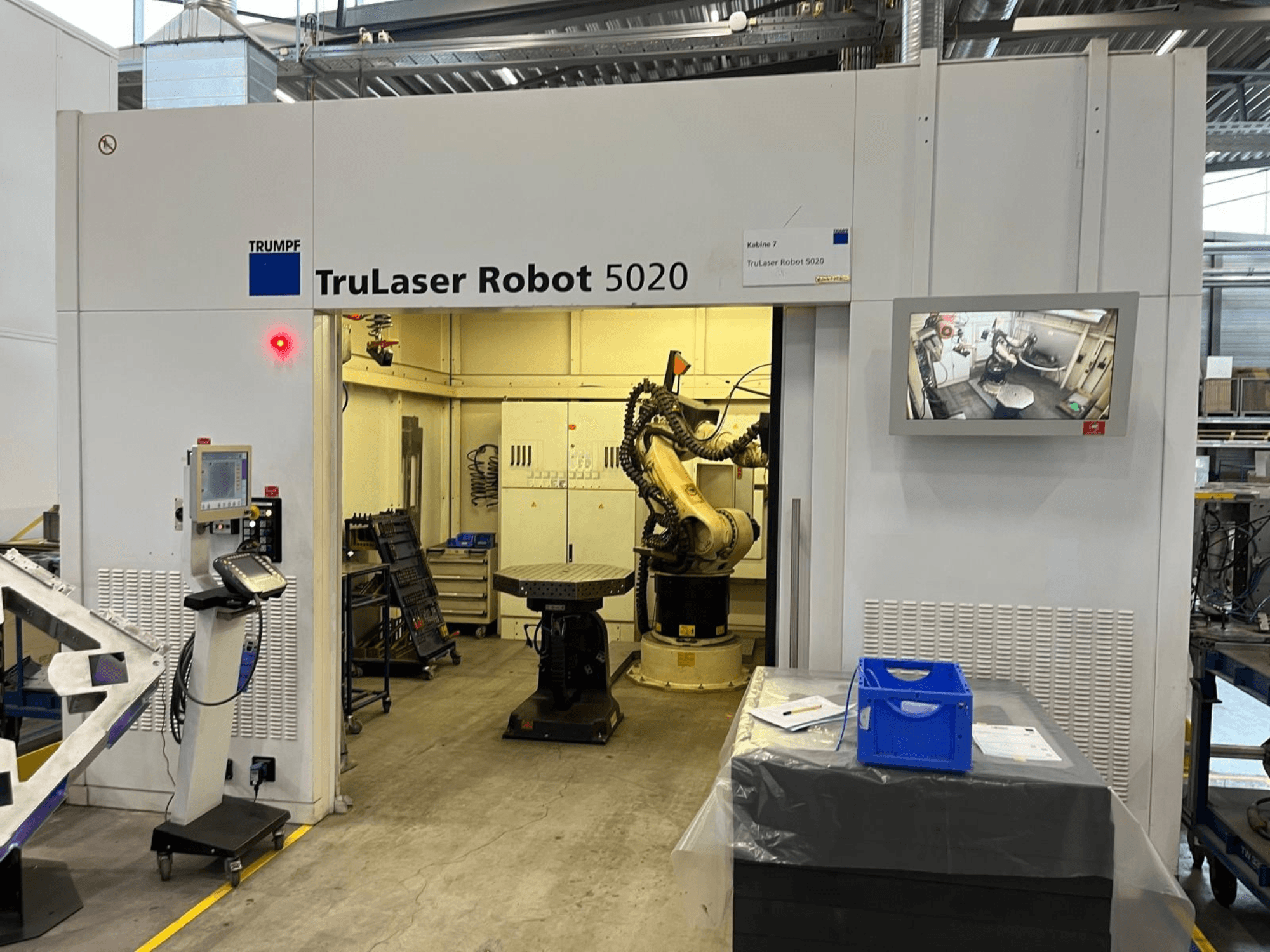 TRUMPF TruLaser Robot 5020 в промышленной обстановке: на снимке видны пульт управления, манипулятор робота и монитор, на котором отображается ход работы.