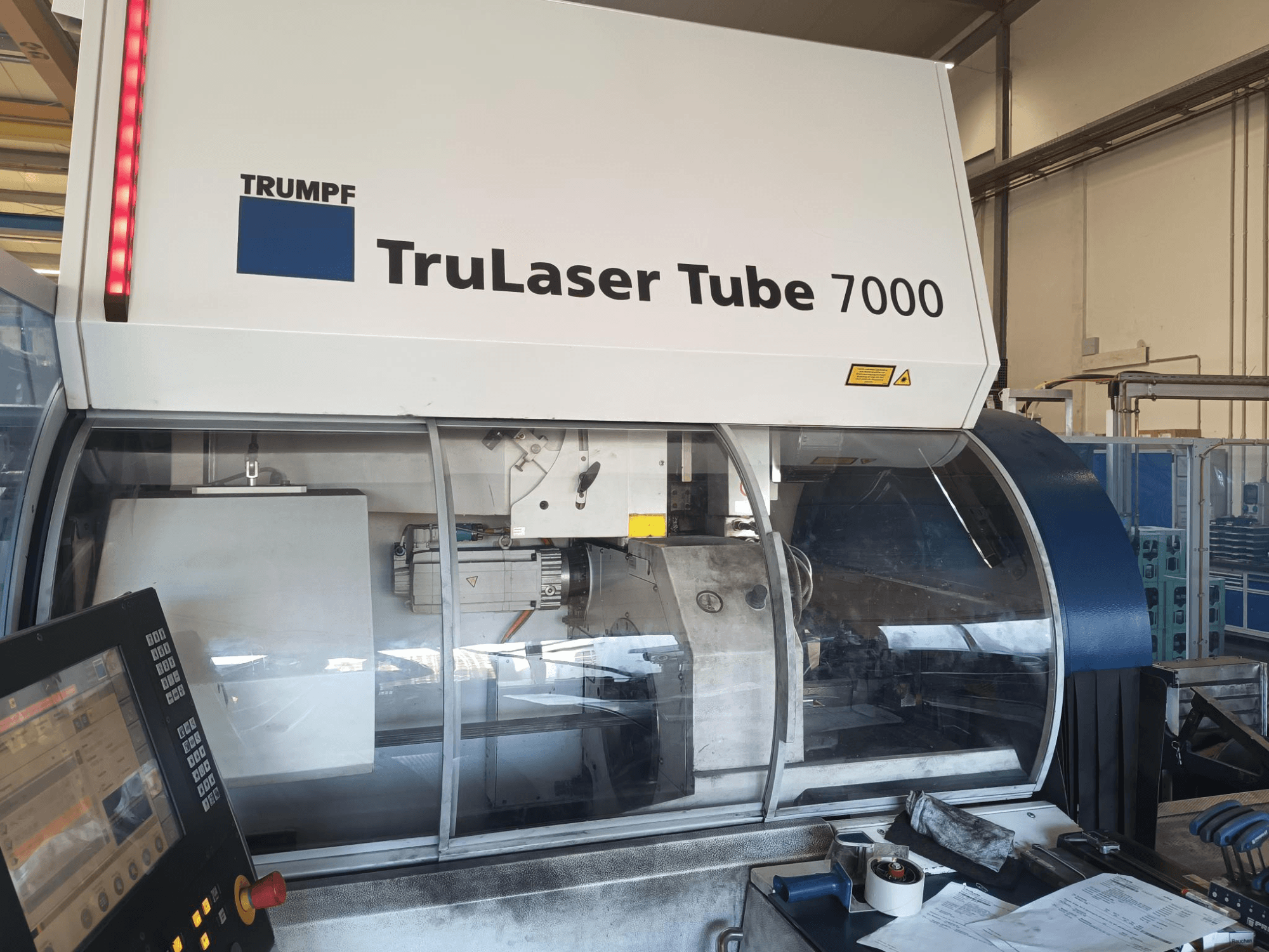 TRUMPF TruLaser Tube 7000, вид спереди на станок с панелью управления, демонстрирующий функции лазерной резки и рабочее пространство.