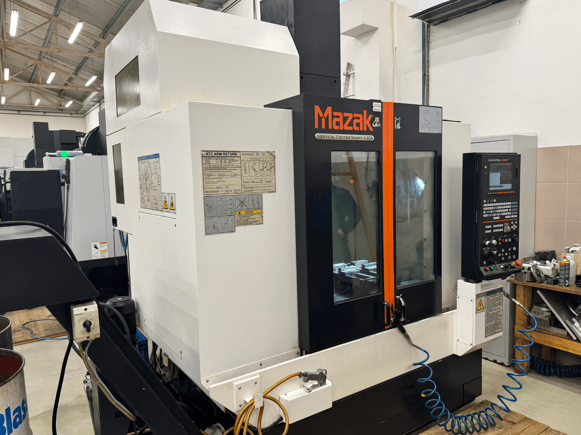 Вертикальный центр Mazak Smart 430A, вид спереди; фрезерный станок с ЧПУ с панелью управления, прозрачным корпусом и держателем инструмента.