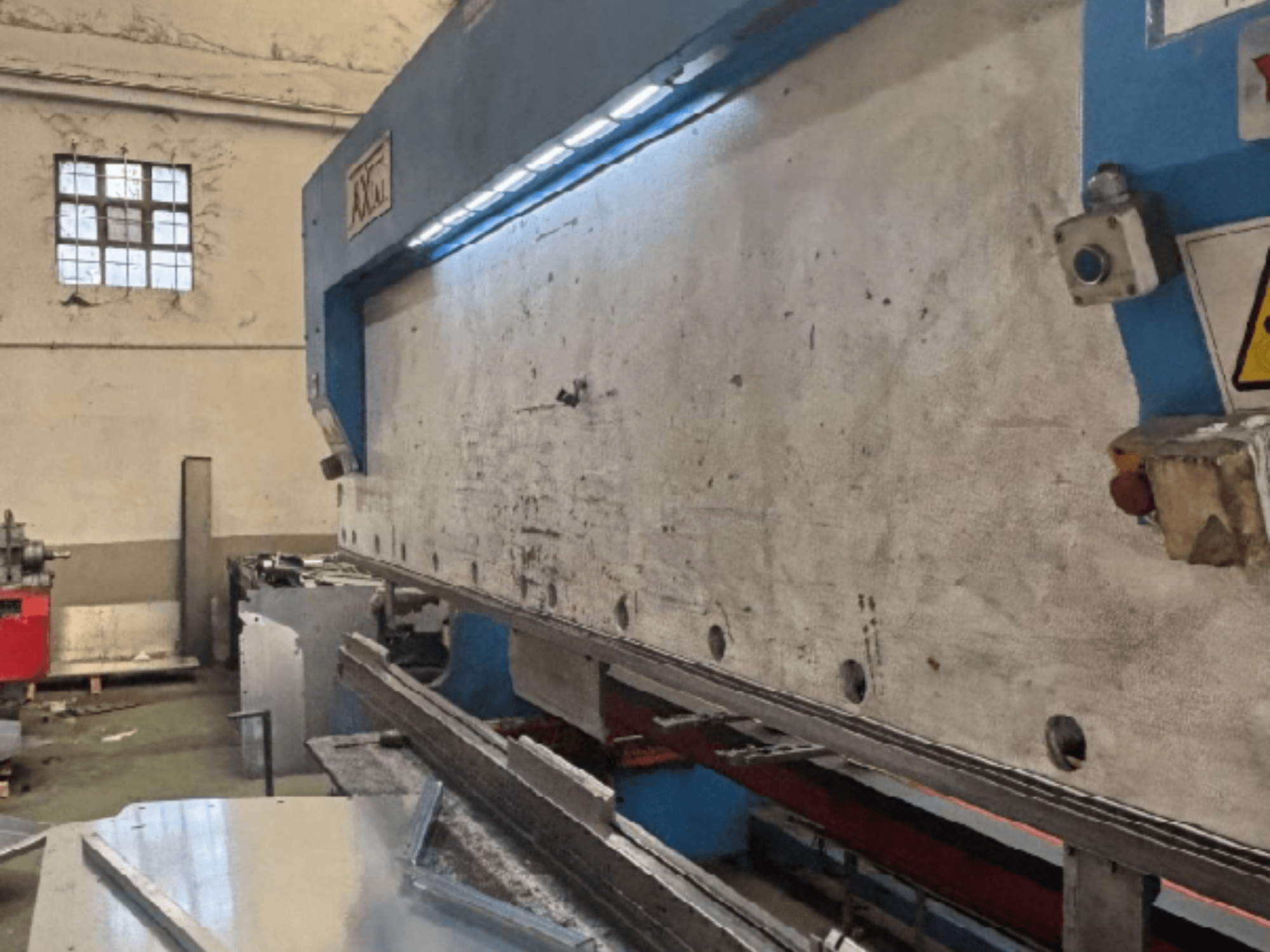 Система перемещения паллет Axial PHS-W-124 в мастерской, вид сбоку, показывающий рабочую поверхность и детали панели управления.