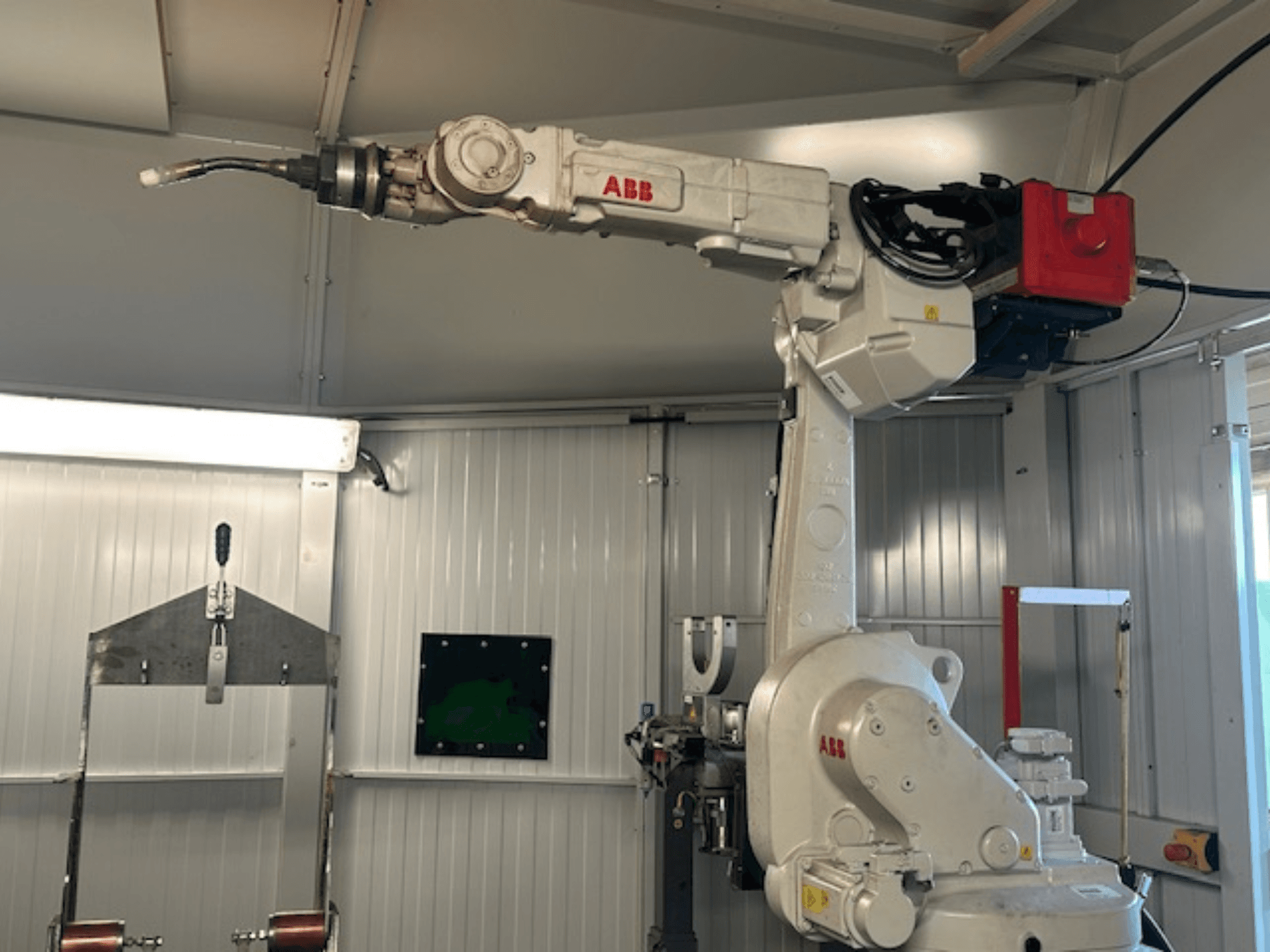 ABB Schweißroboter Flex Arc - вид сбоку на роботизированную руку со сварочным инструментом, демонстрирующий такие детали, как панель управления и кабели.