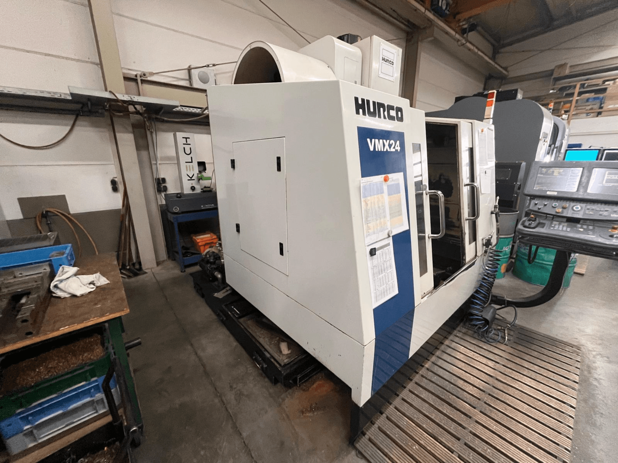 Станок с ЧПУ Hurco VMX24 в мастерской, вид спереди; панель управления и открытая дверца.