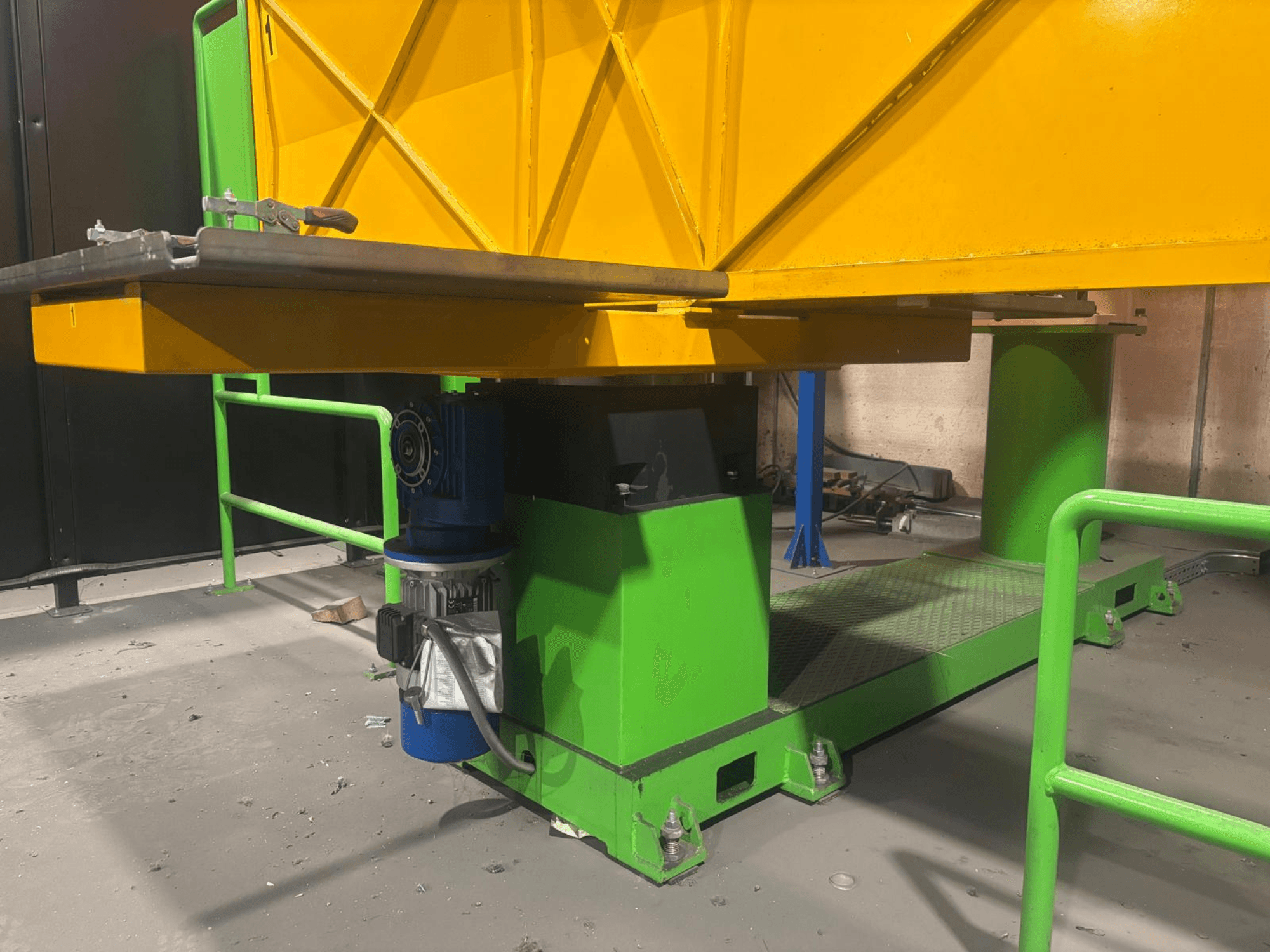 Зеленые и желтые промышленные машины с видом спереди, с изображением двигателя и платформы с текстурированной поверхностью.