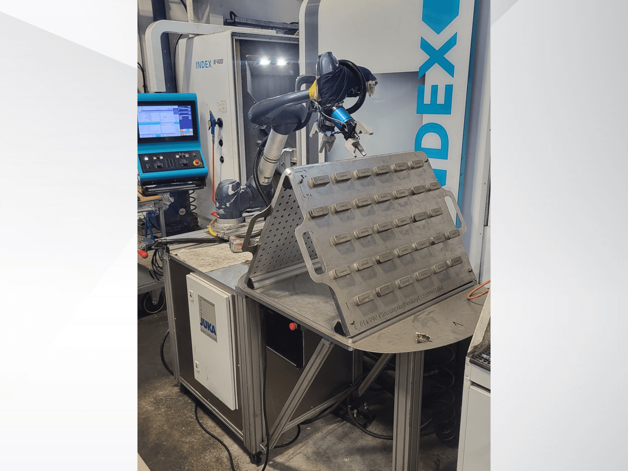 Коллаборативный робот DOOSAN M1013 вид спереди, расположенный возле рабочего стола с держателем инструментов и панелью управления.