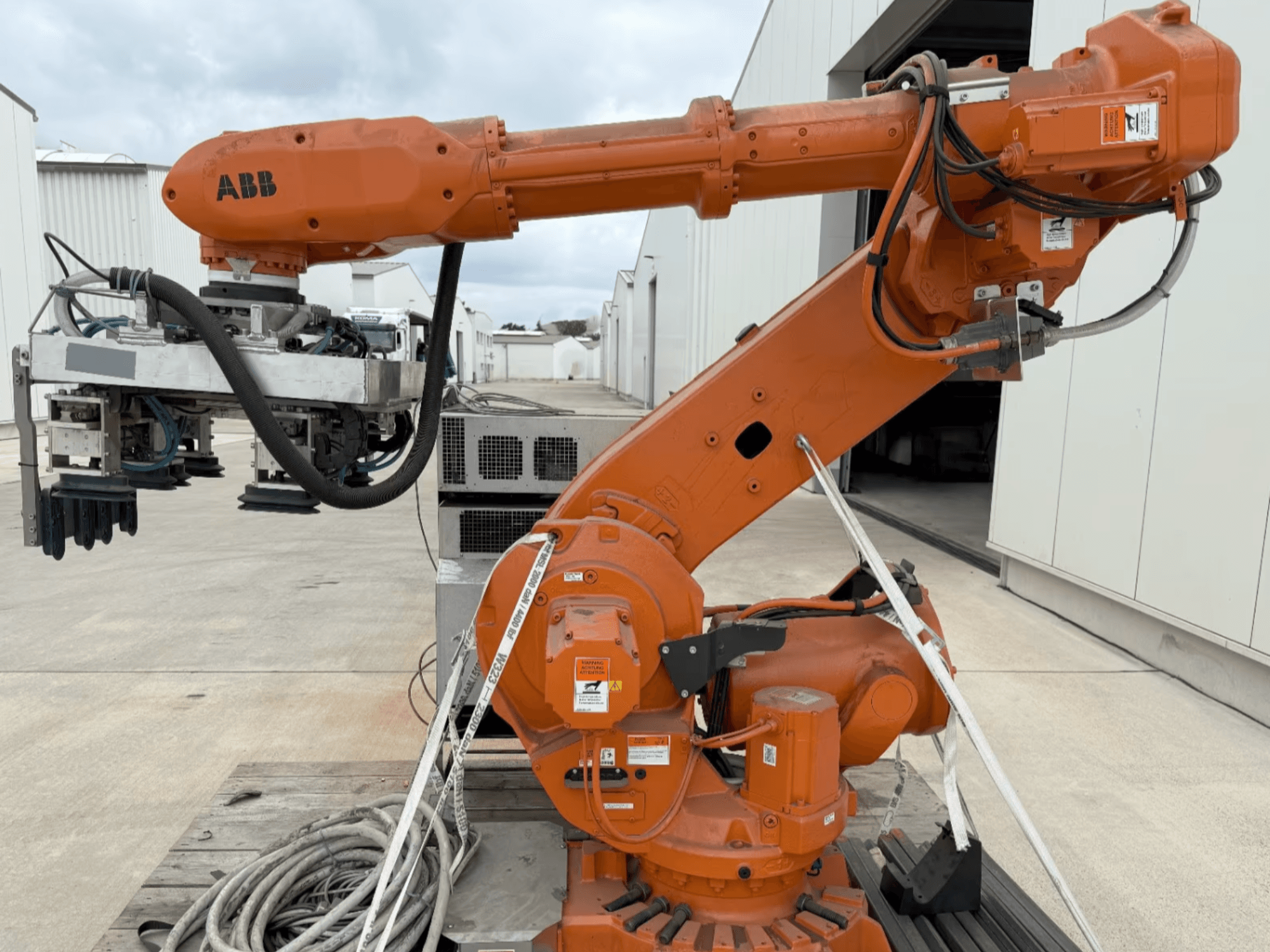 Роботизированная рука ABB RB 6600-130/3.2 на виде сбоку, оранжевая рука с захватным устройством и видимой проводкой.