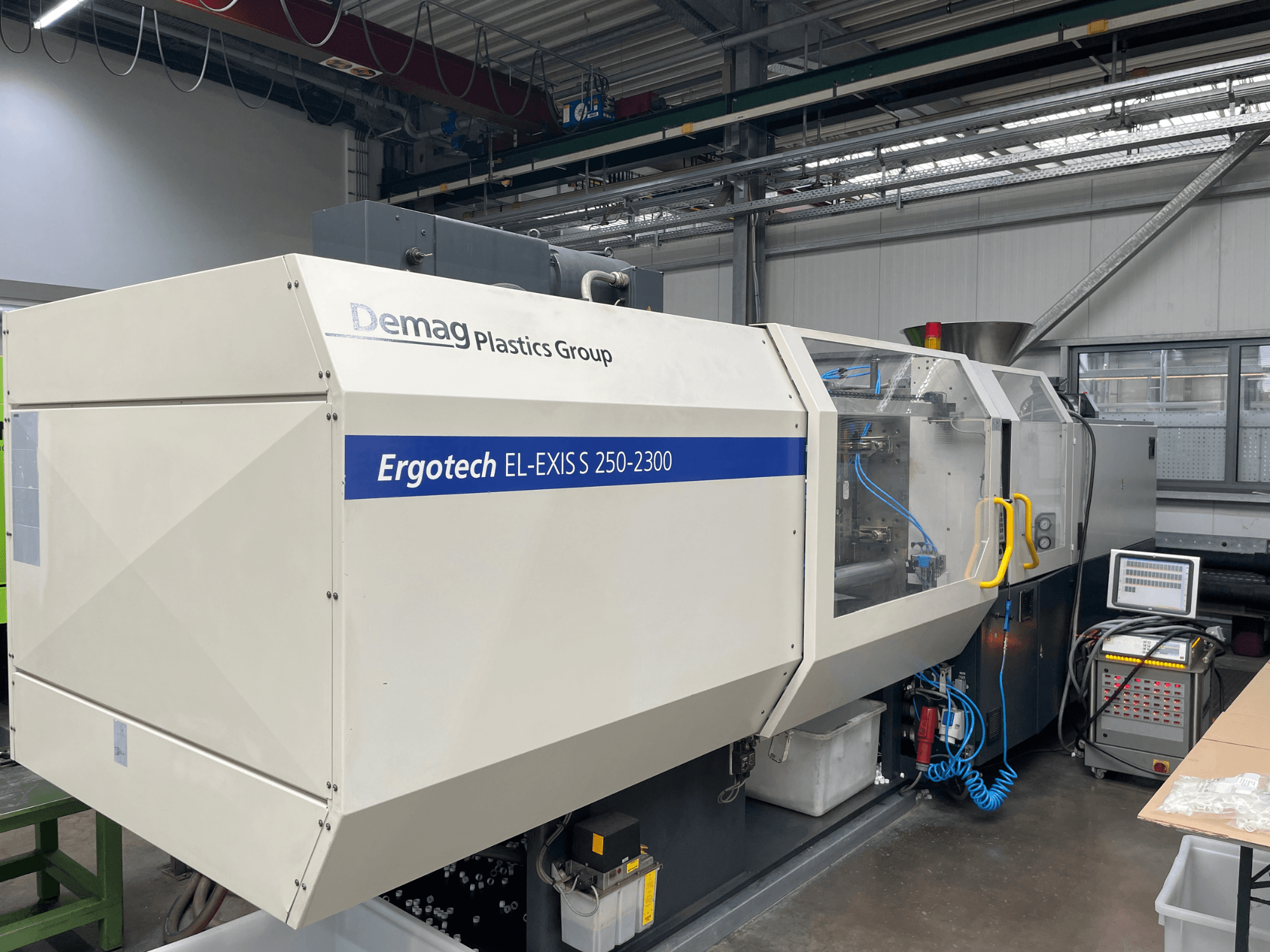 Термопластавтомат Demag Ergotech EL-EXIS S 250-2300, вид сбоку, демонстрирует панель управления и систему подачи.