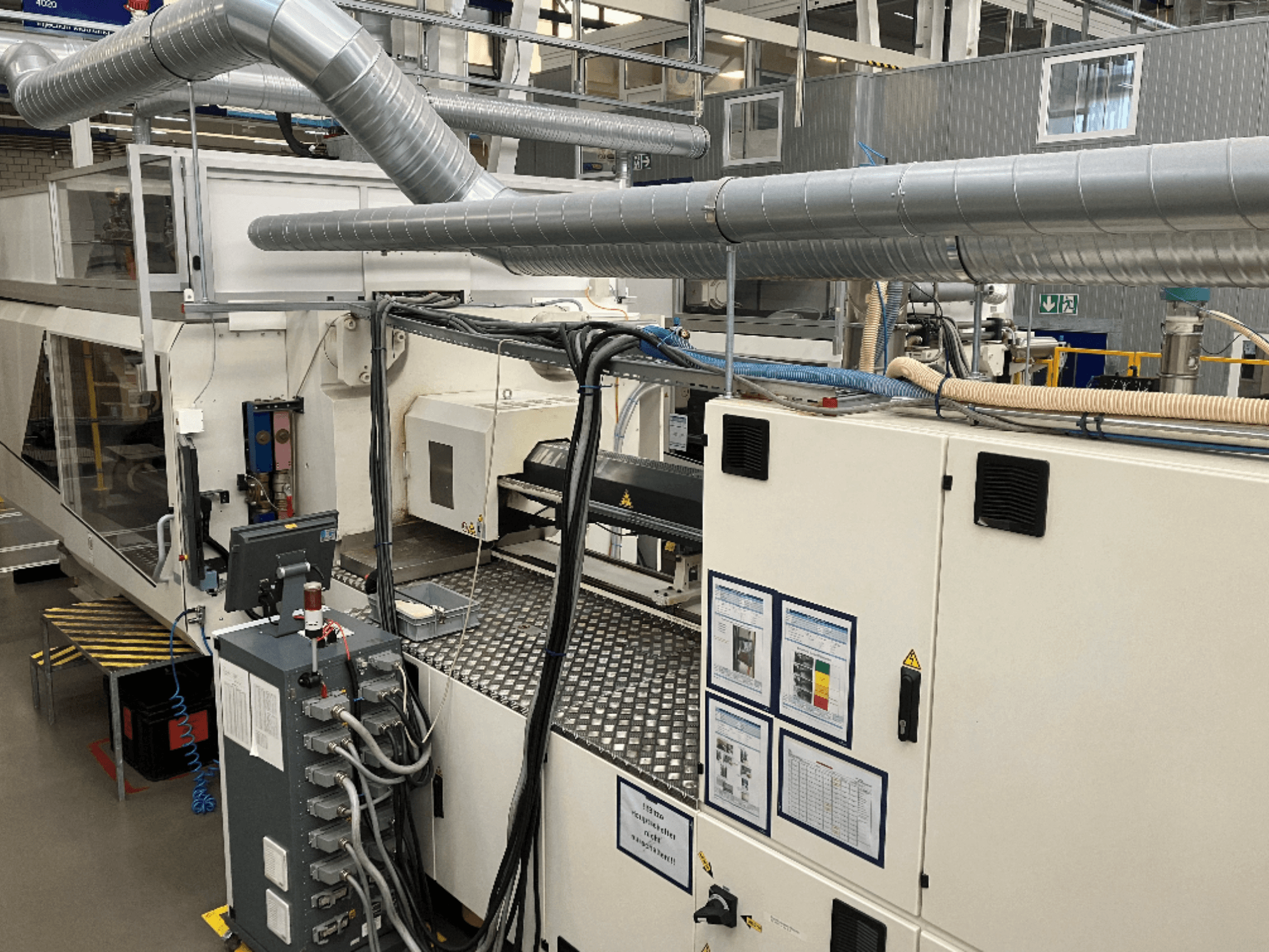 Промышленное оборудование с обширными трубопроводами, панелями управления и руководствами по эксплуатации, рассматриваемое сверху вниз.